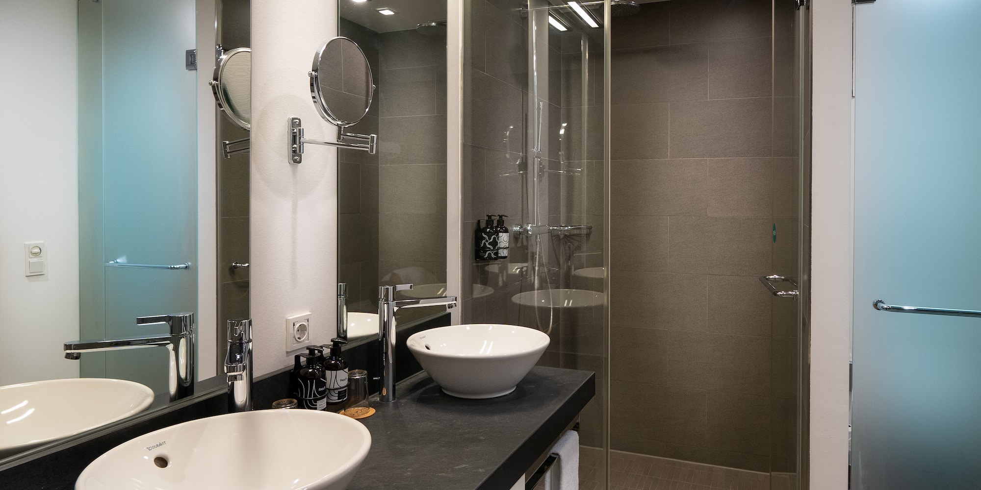 a bathroom with two sinks and a shower