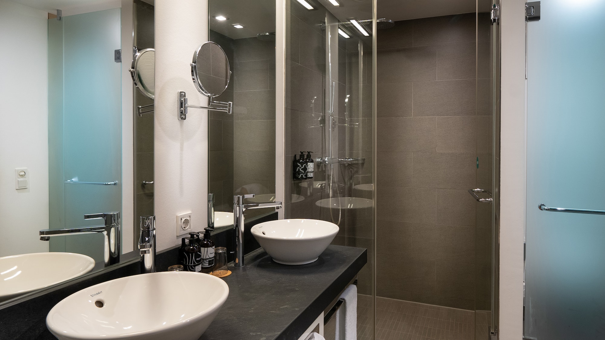 a bathroom with two sinks and a shower