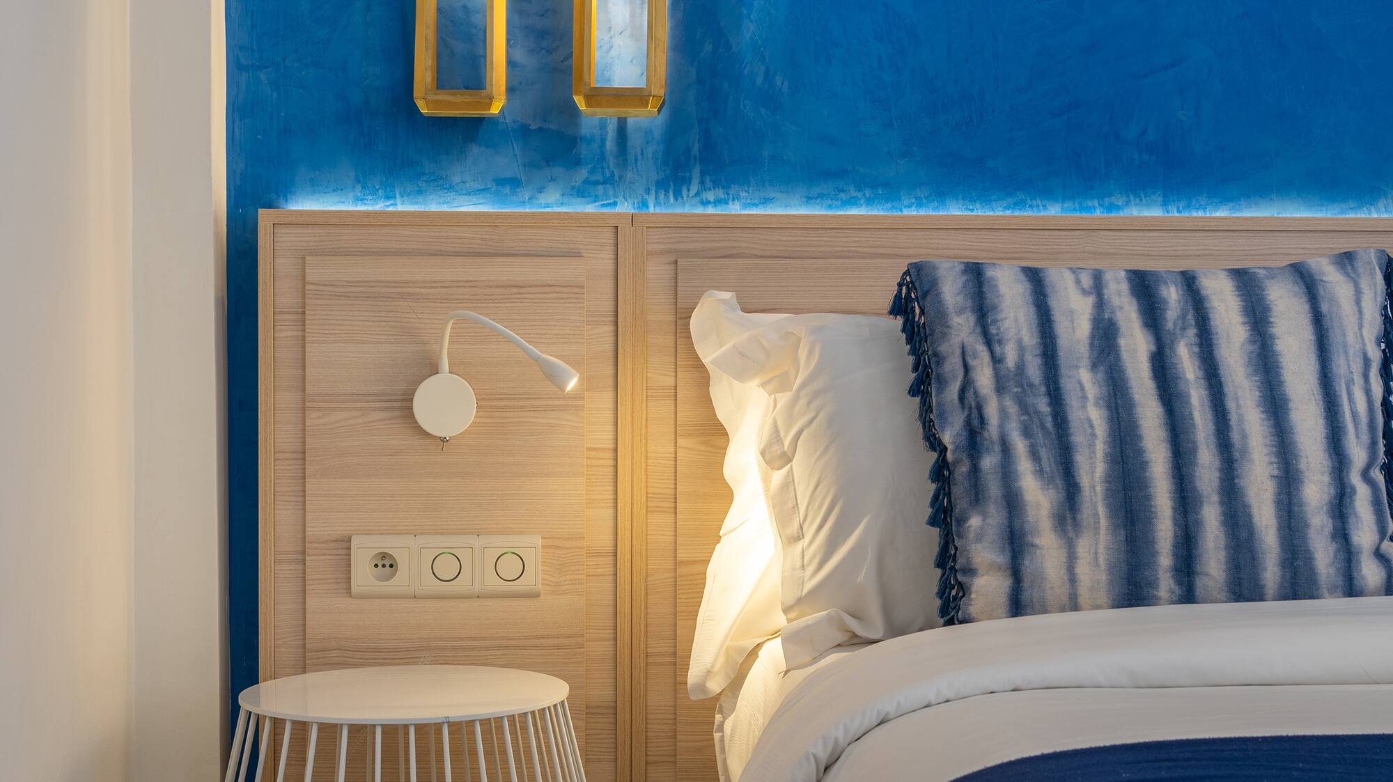 a bed with a blue and white blanket and a table