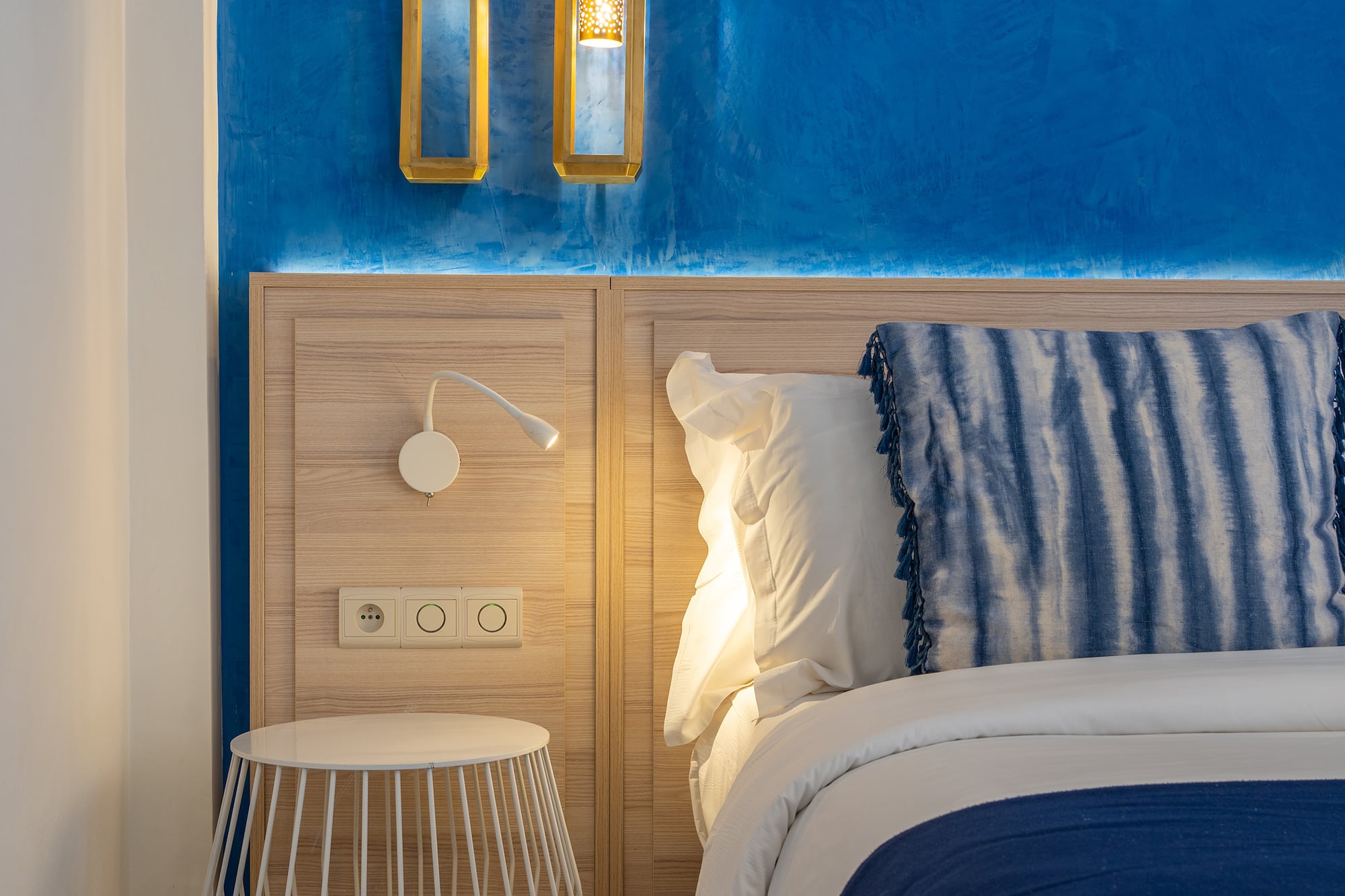 a bed with a blue and white blanket and a table