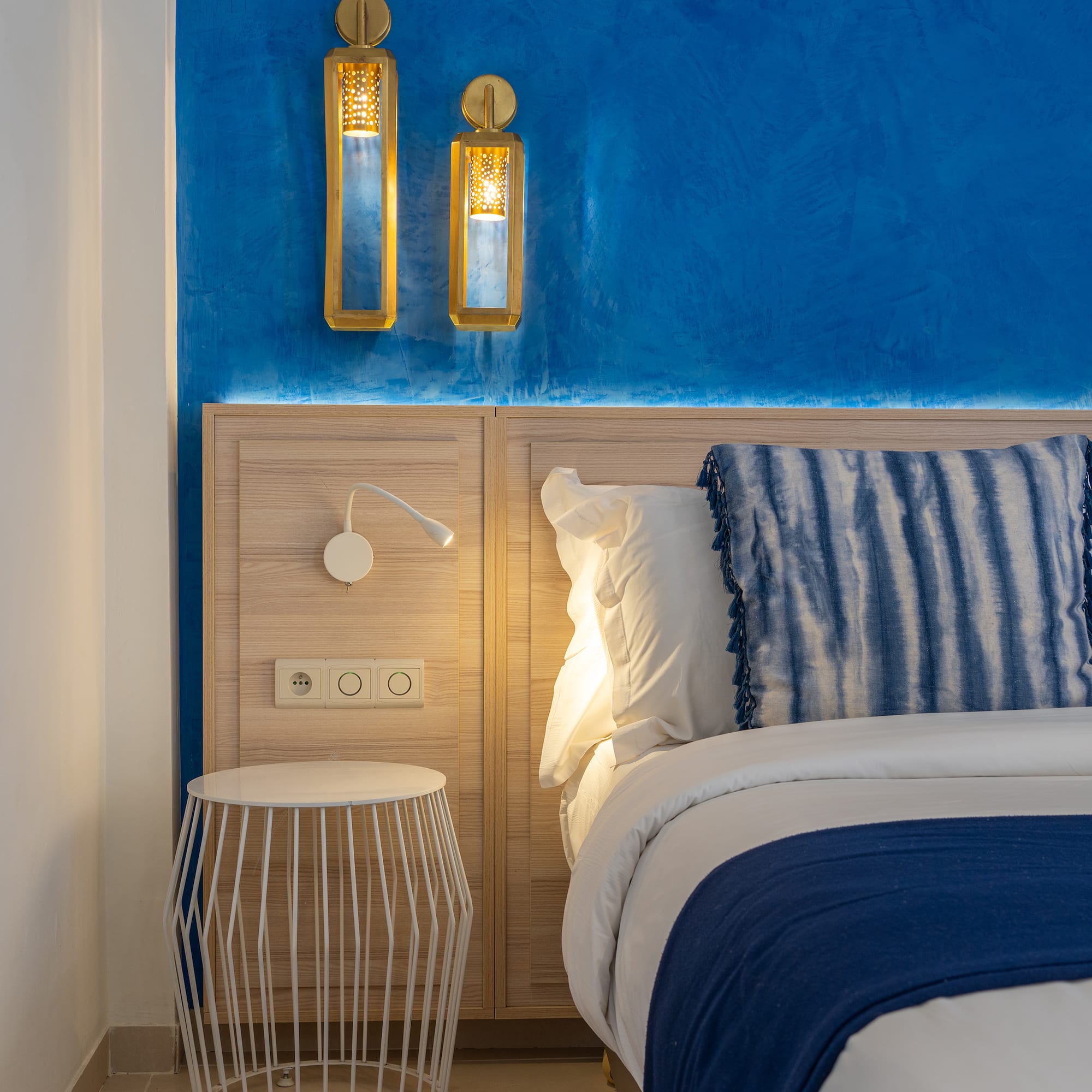 a bed with a blue and white blanket and a table