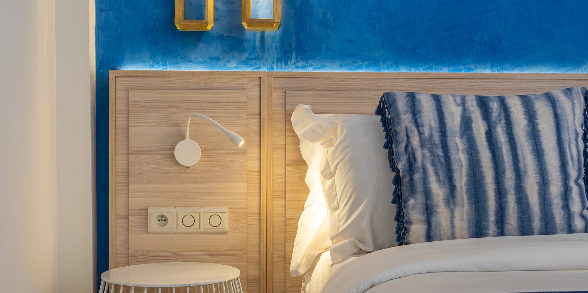 a bed with a blue and white blanket and a table