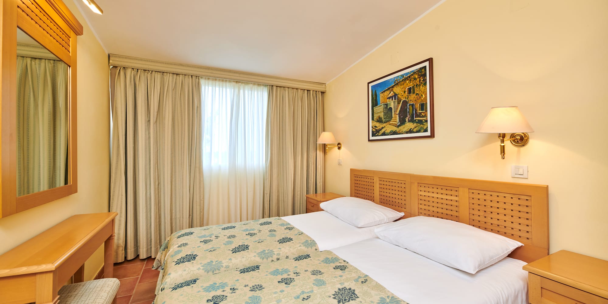 a bed with a wood headboard and a lamp on the wall