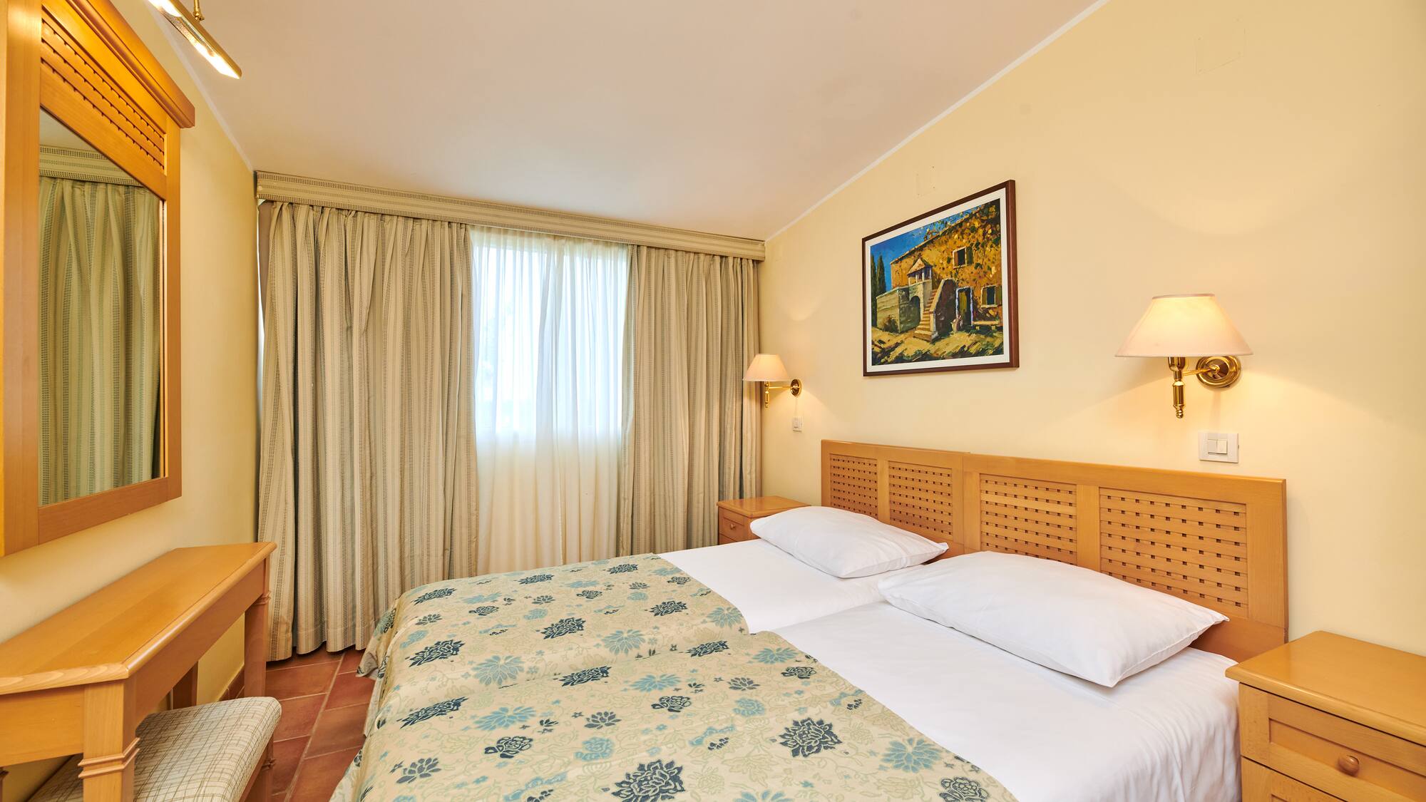 a bed with a wood headboard and a lamp on the wall