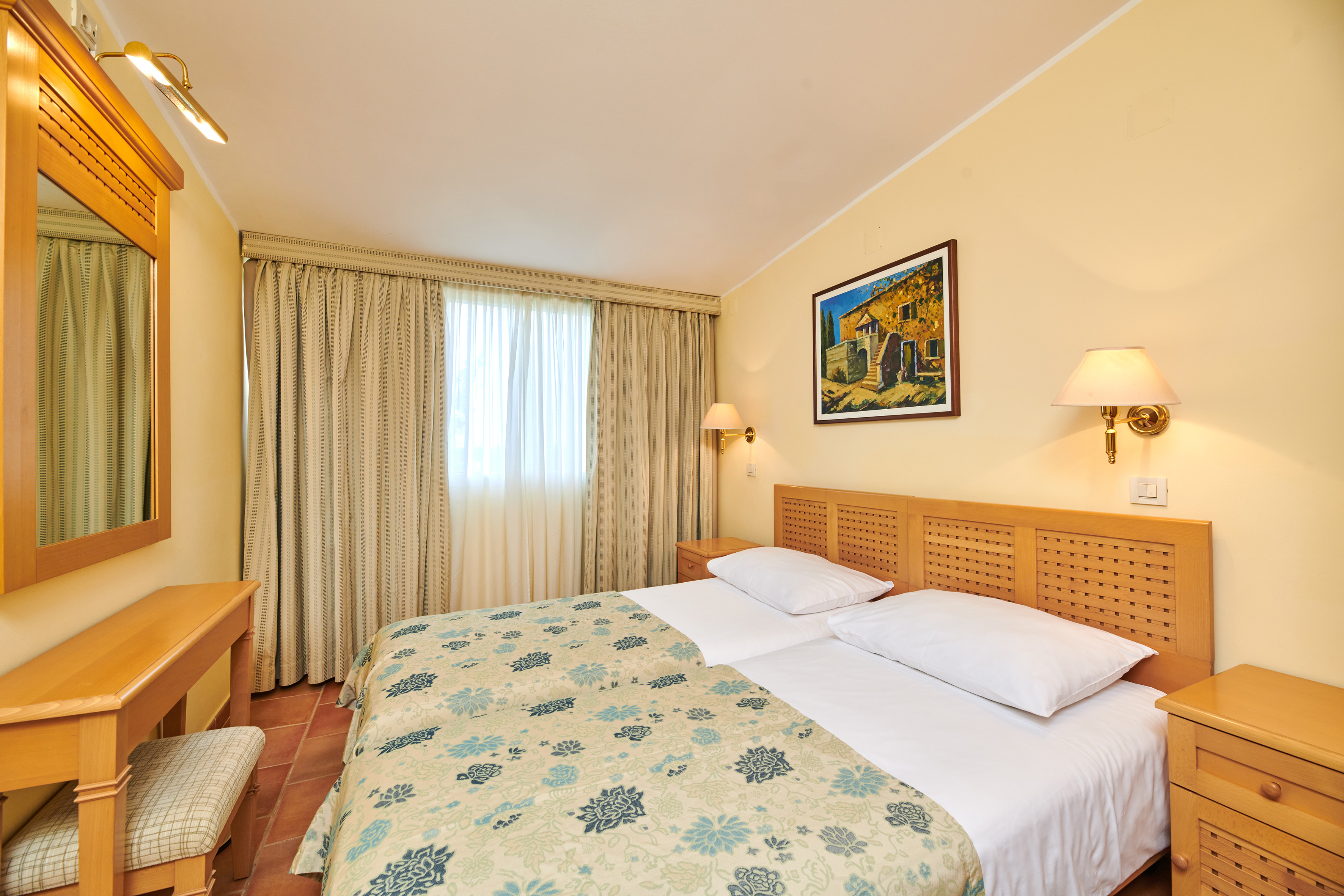 a bed with a wood headboard and a lamp on the wall