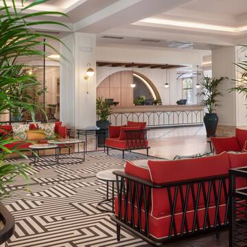 a room with red couches and a black and white patterned floor