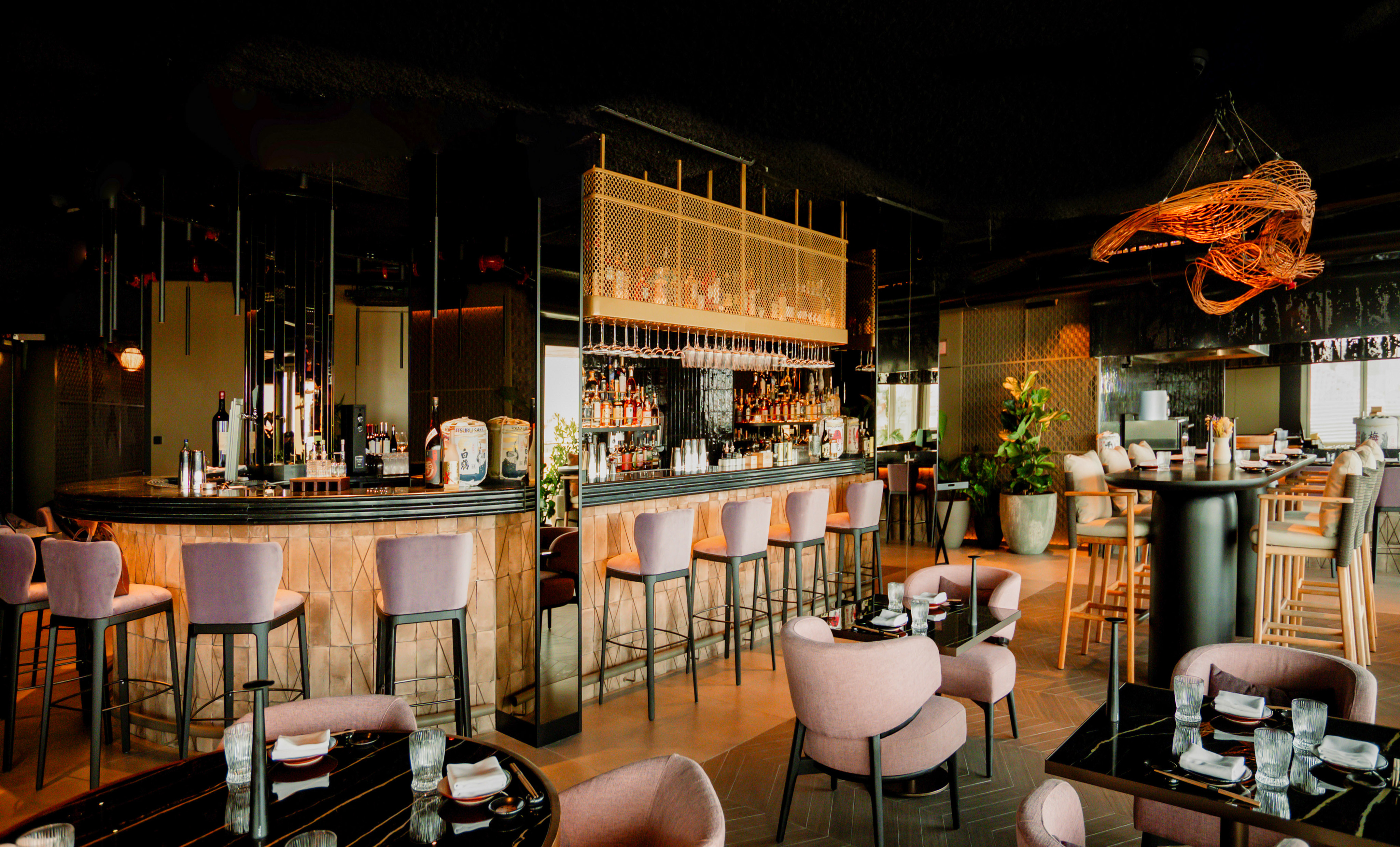 Modern restaurant bar with stylish pink seating and elegant interior design.