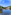 Lake with docked pedal boats, lush green trees, and a waterfront restaurant under blue sky.
