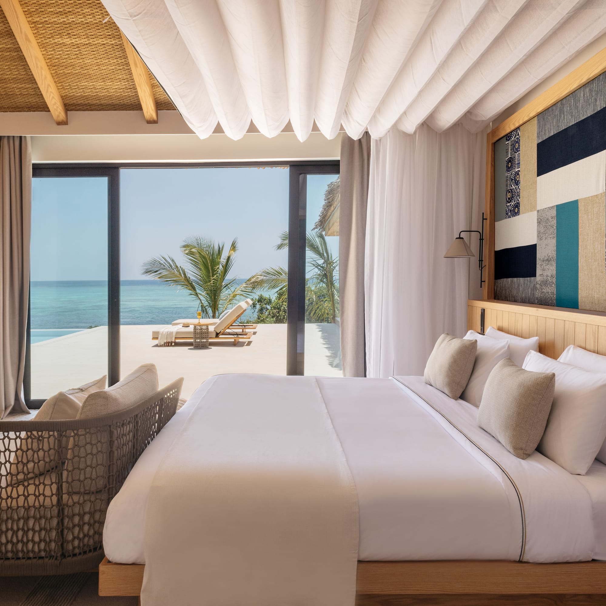 a bed with a chair and a chair next to a beach