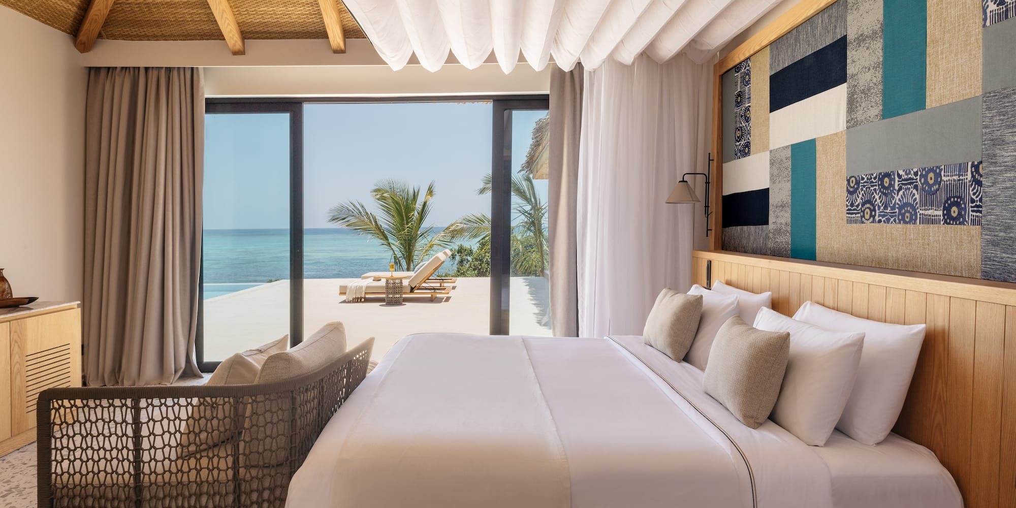 a bed with a chair and a chair next to a beach