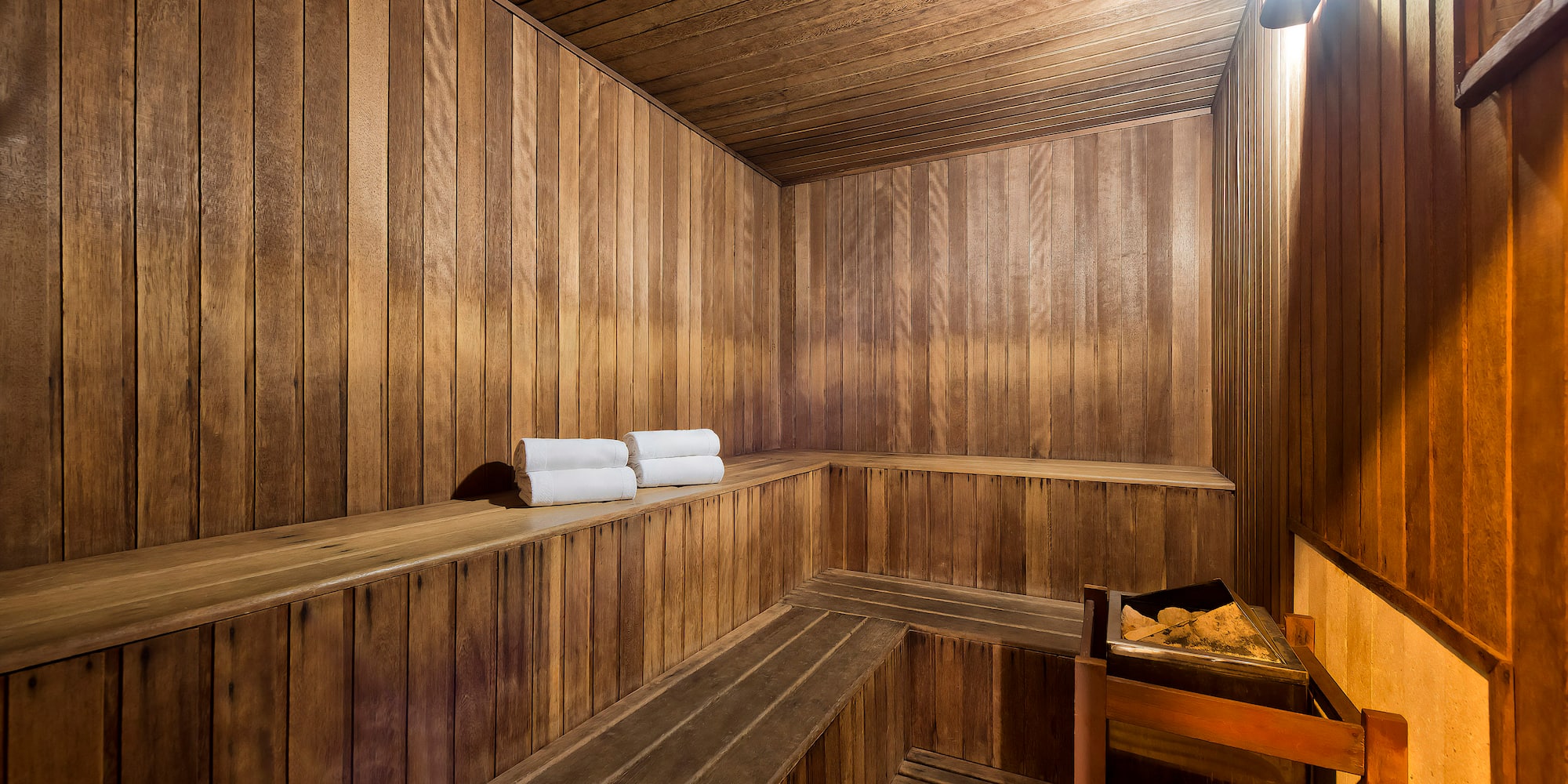 a wooden sauna with a bucket and towels
