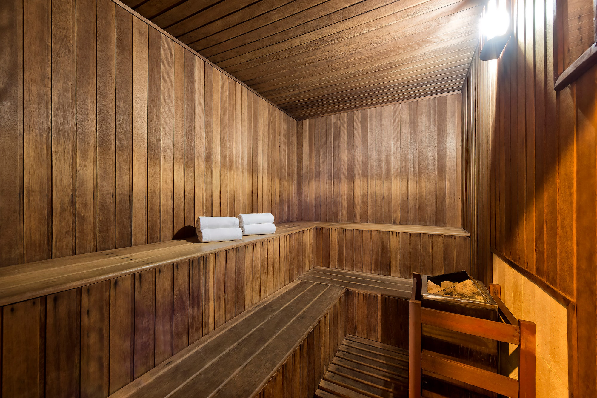 a wooden sauna with a bucket and towels