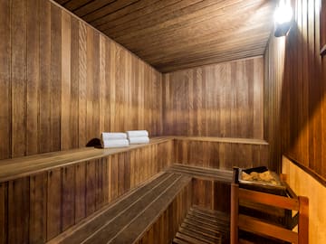 a wooden sauna with a bucket and towels