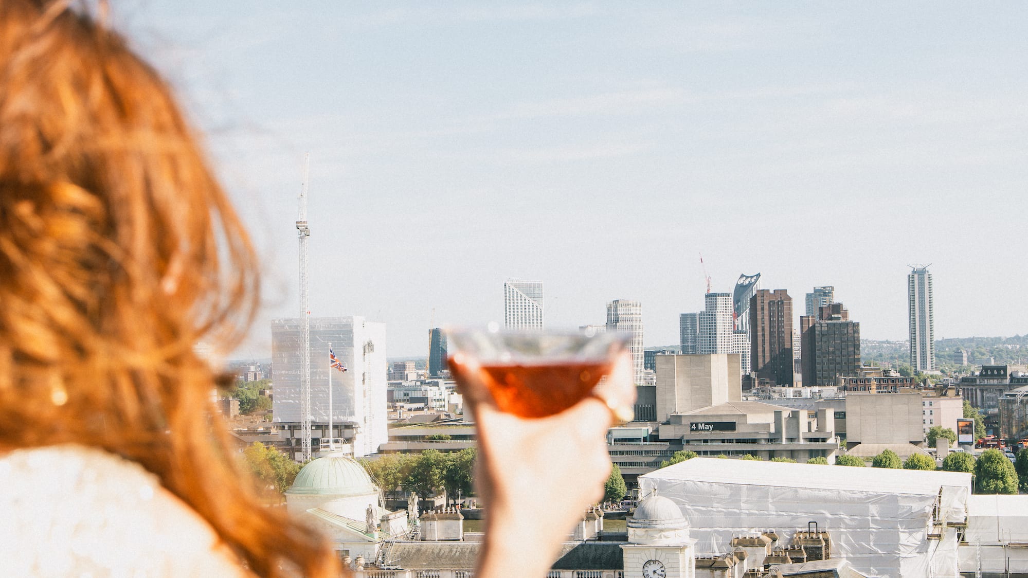 a woman holding a drink in a city