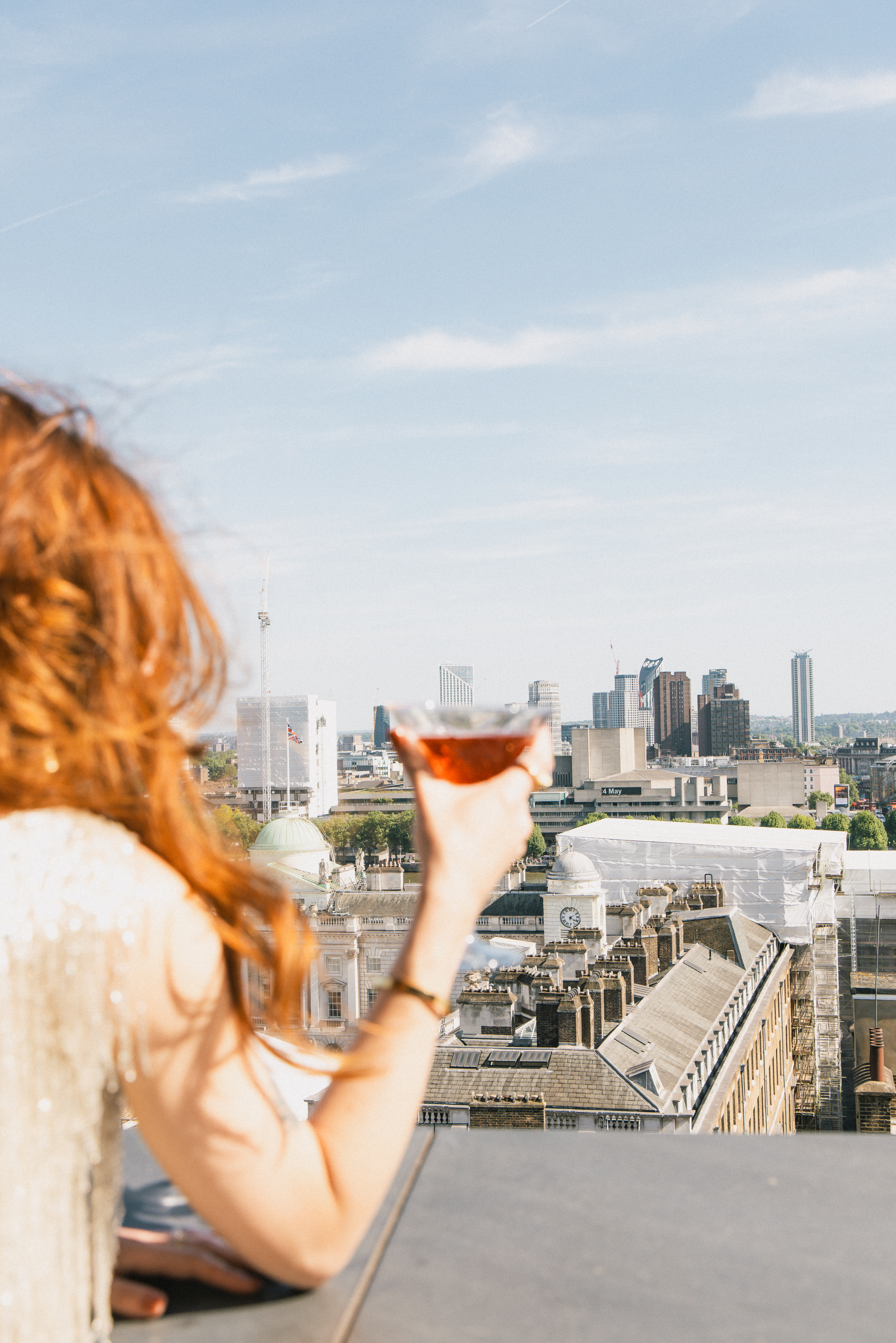 a woman holding a drink in a city