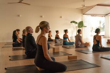 a group of people sitting on mats in a room