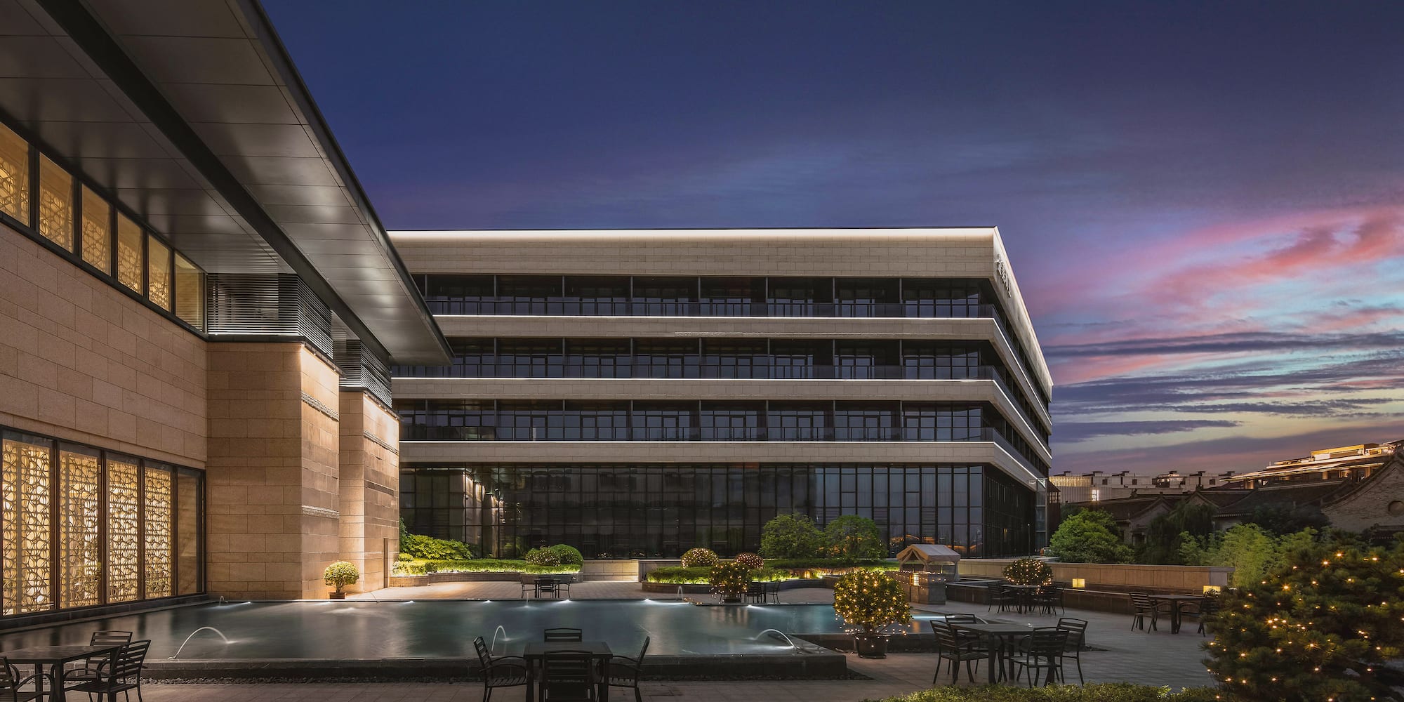a building with a pool and chairs