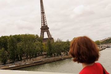 a woman looking at the eiffel tower