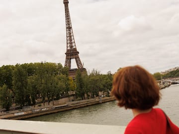 a woman looking at the eiffel tower