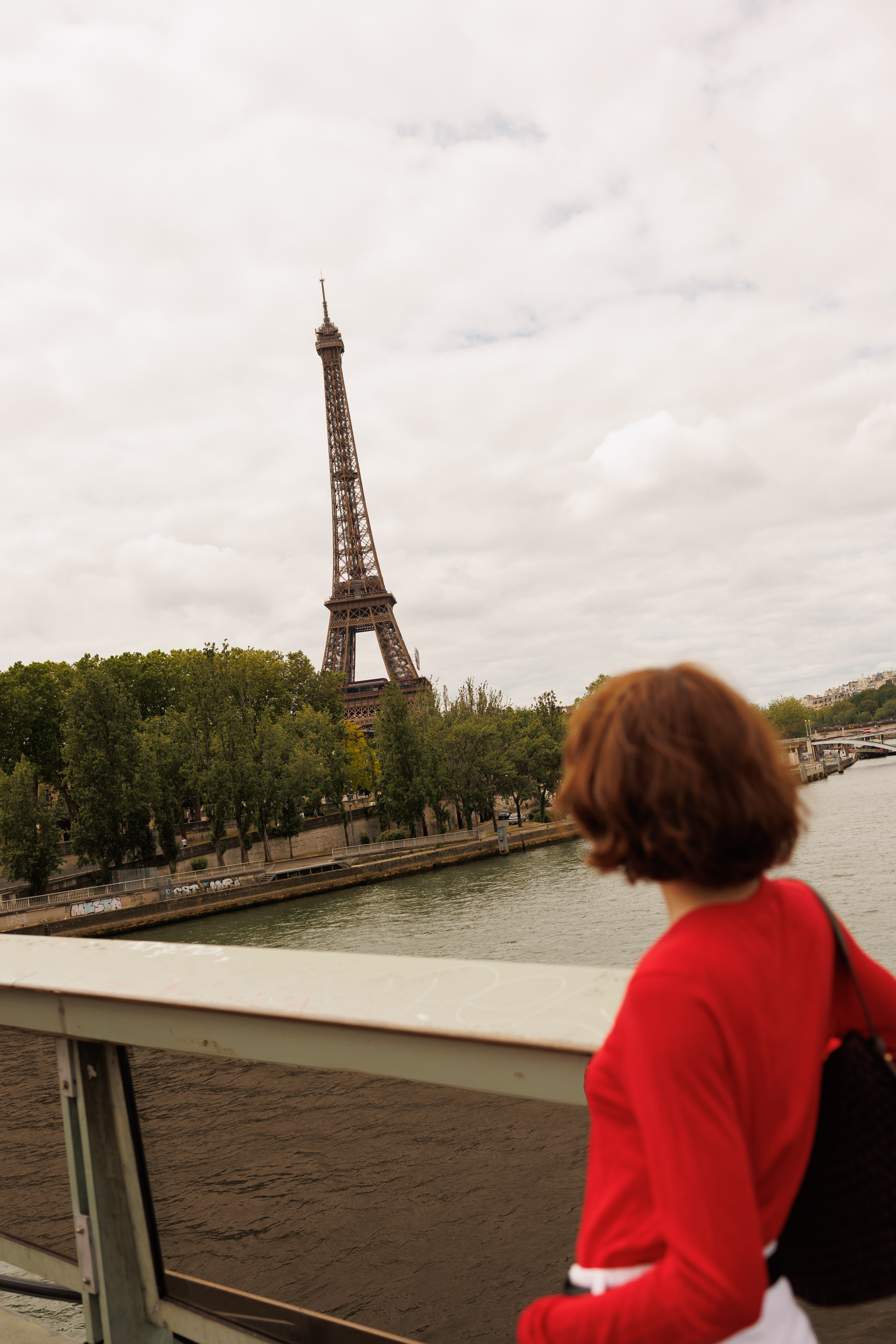 Tourist on bridge viewing Eiffel Tower and Seine River in Paris.
