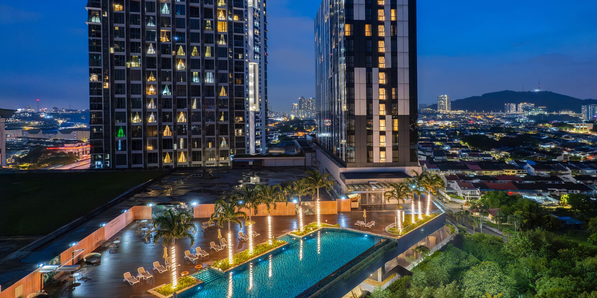 a pool and buildings with trees and lights