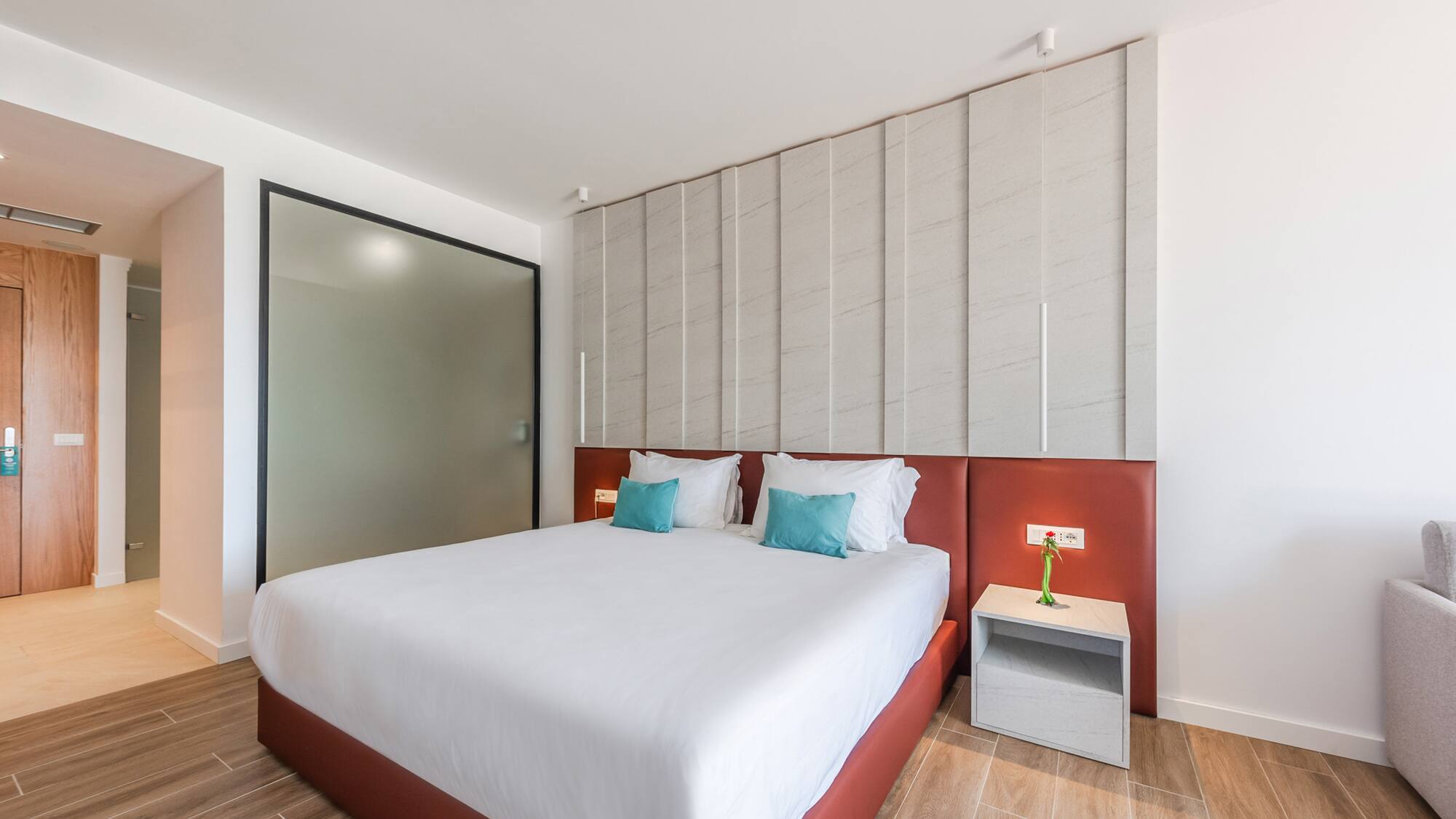 a bed with pillows and a table next to a door