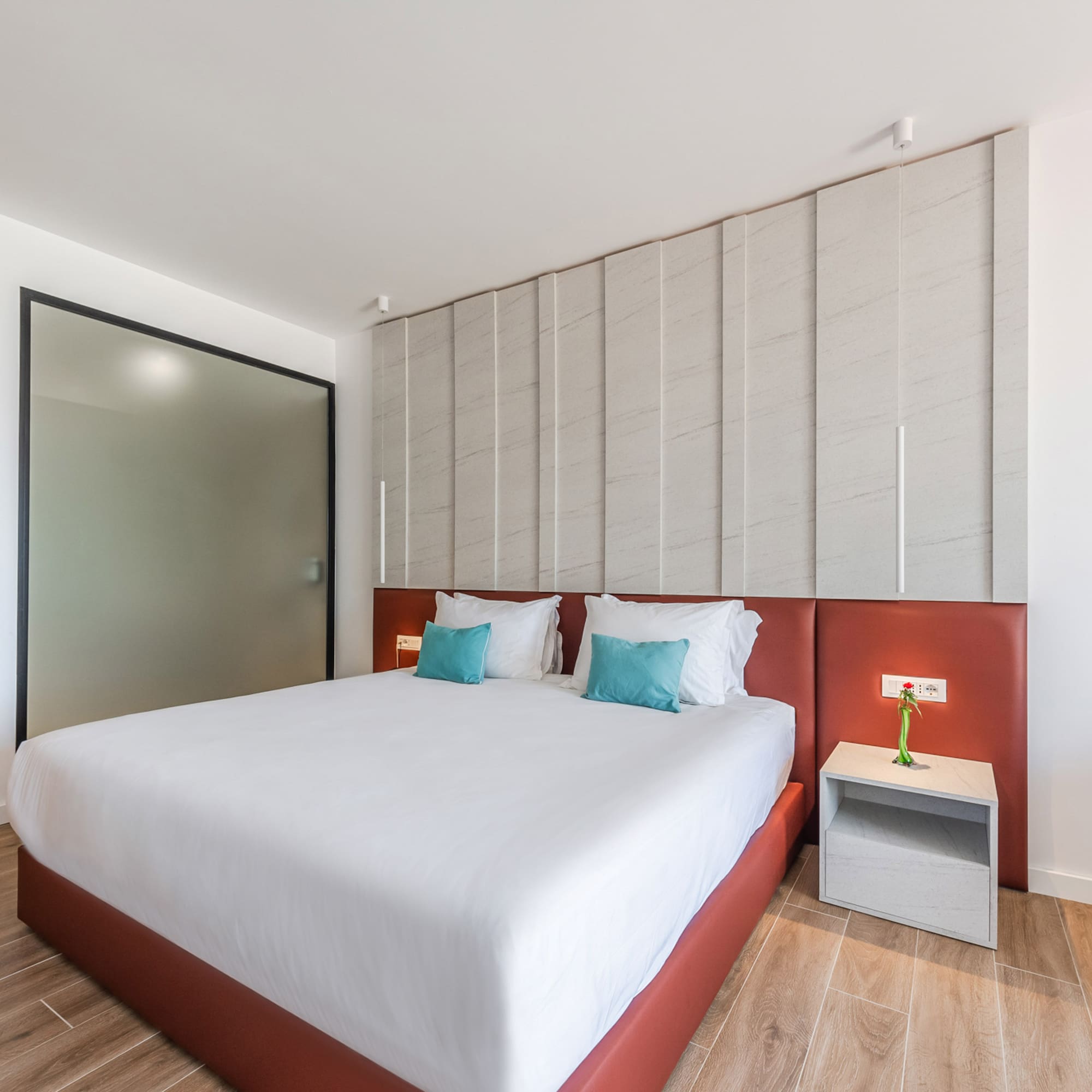 a bed with pillows and a table next to a door