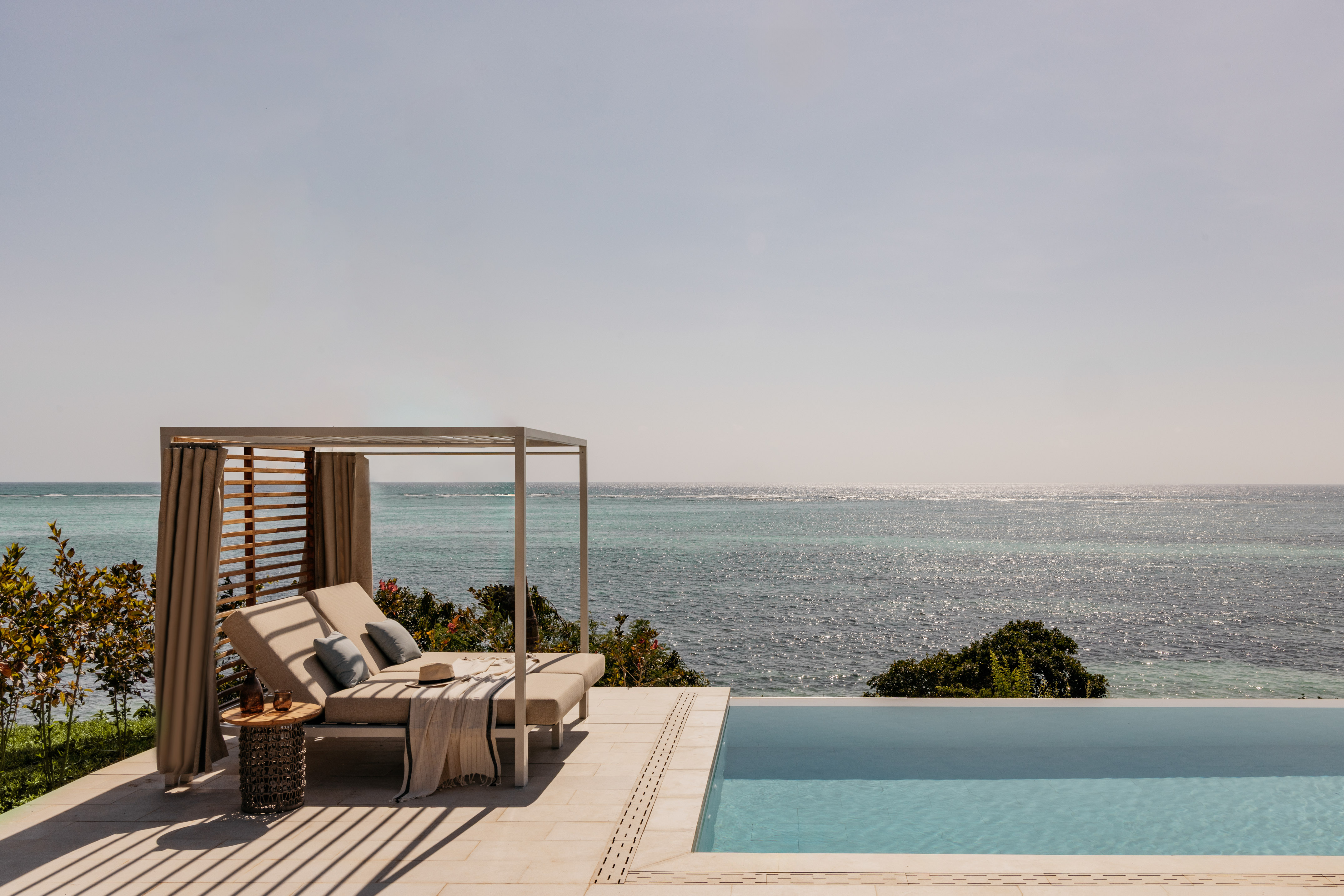 Luxury cabana and infinity pool overlooking a tropical ocean.