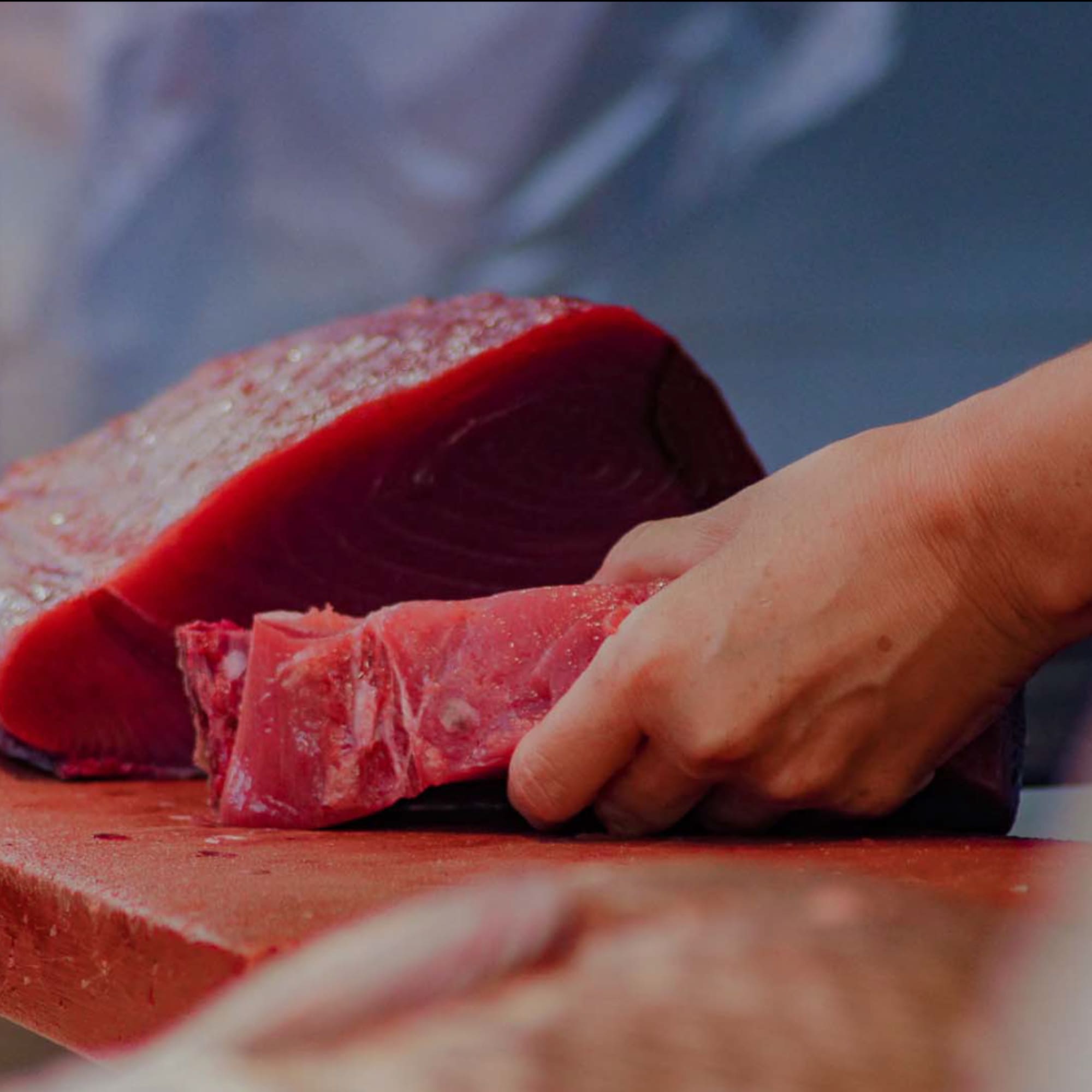 a person cutting a piece of meat