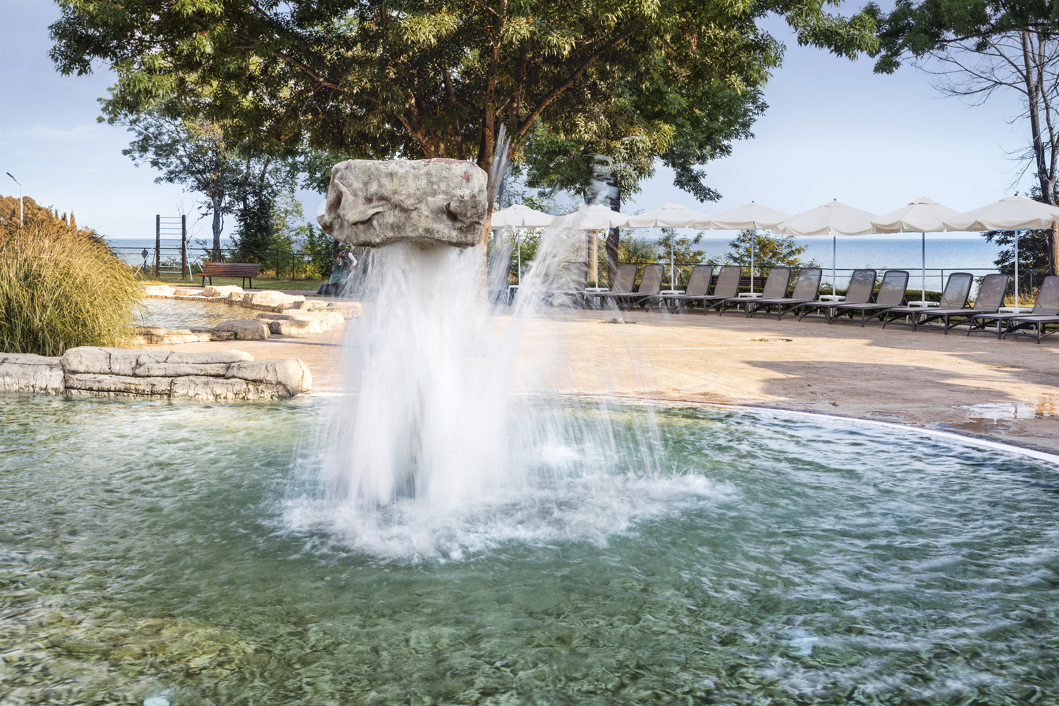 a water fountain with a rock in the air