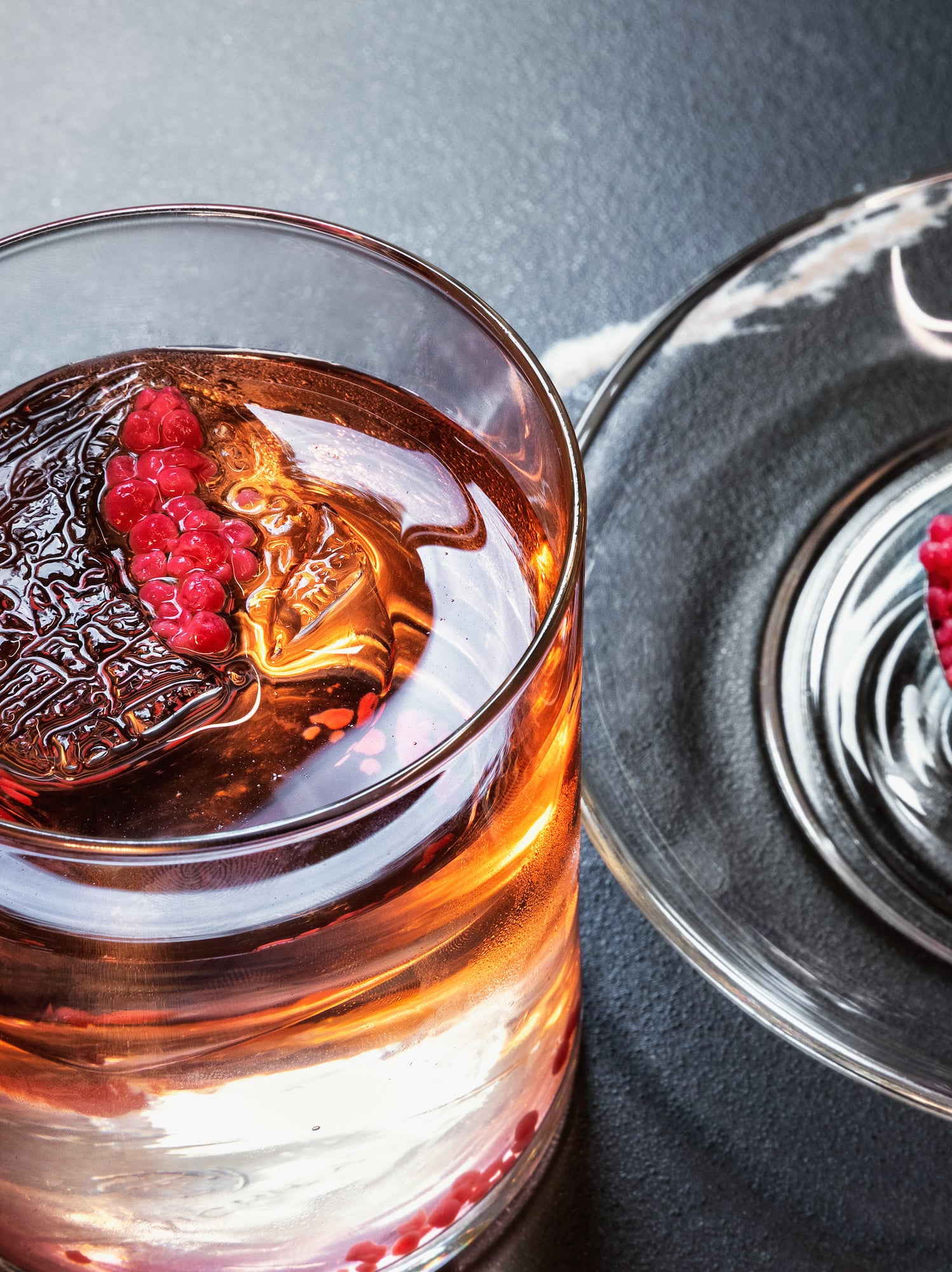 a glass of liquid with a spoon and a spoon on a plate