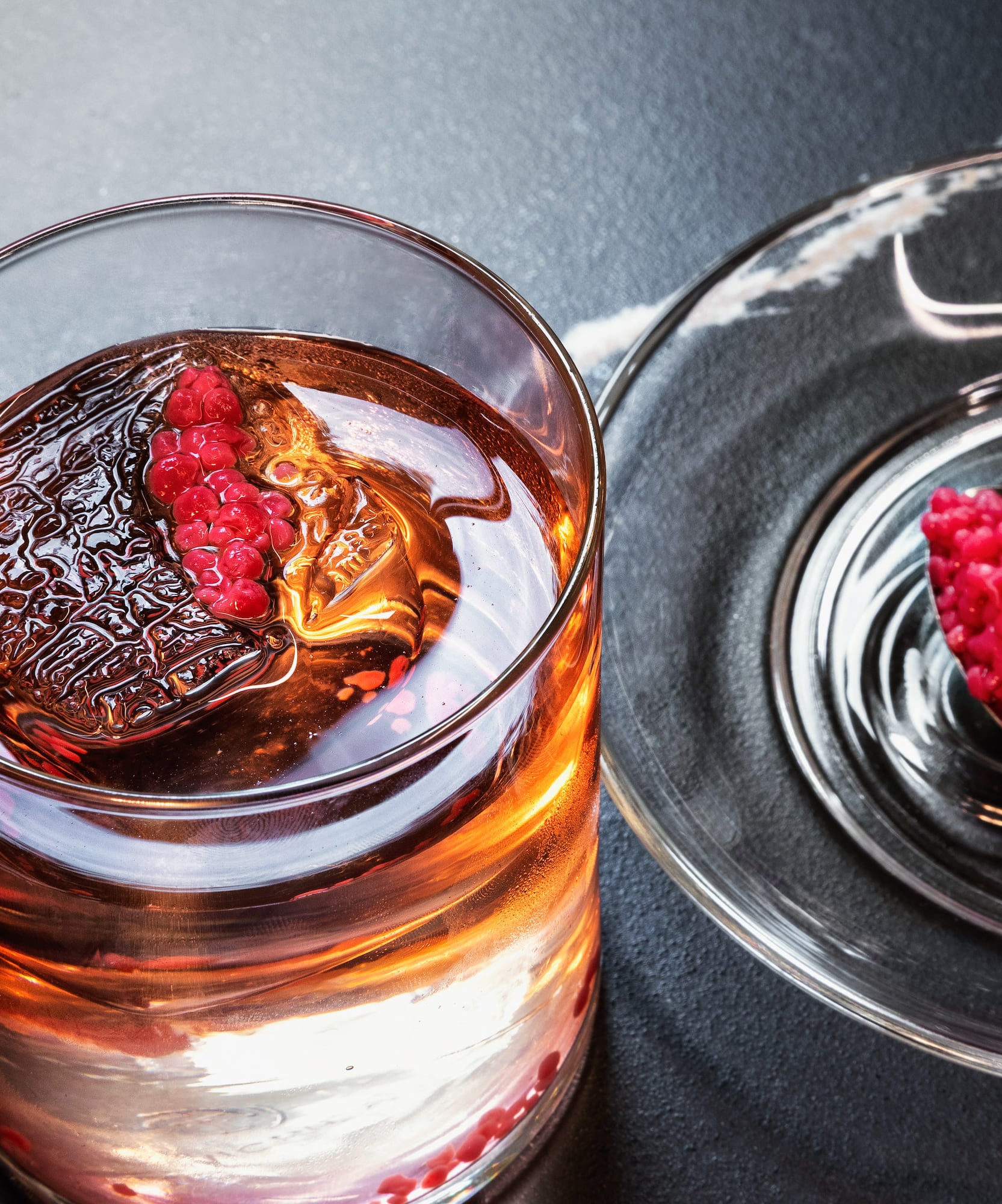 a glass of liquid with a spoon and a spoon on a plate