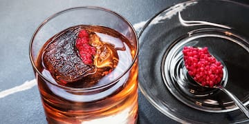 a glass of liquid with a spoon and a spoon on a plate