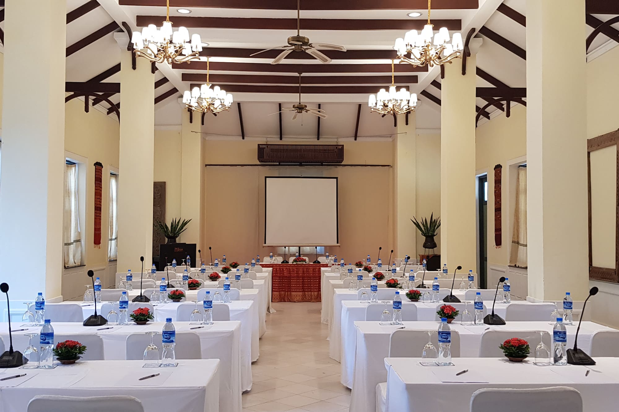 a room with tables and chairs and a projector screen