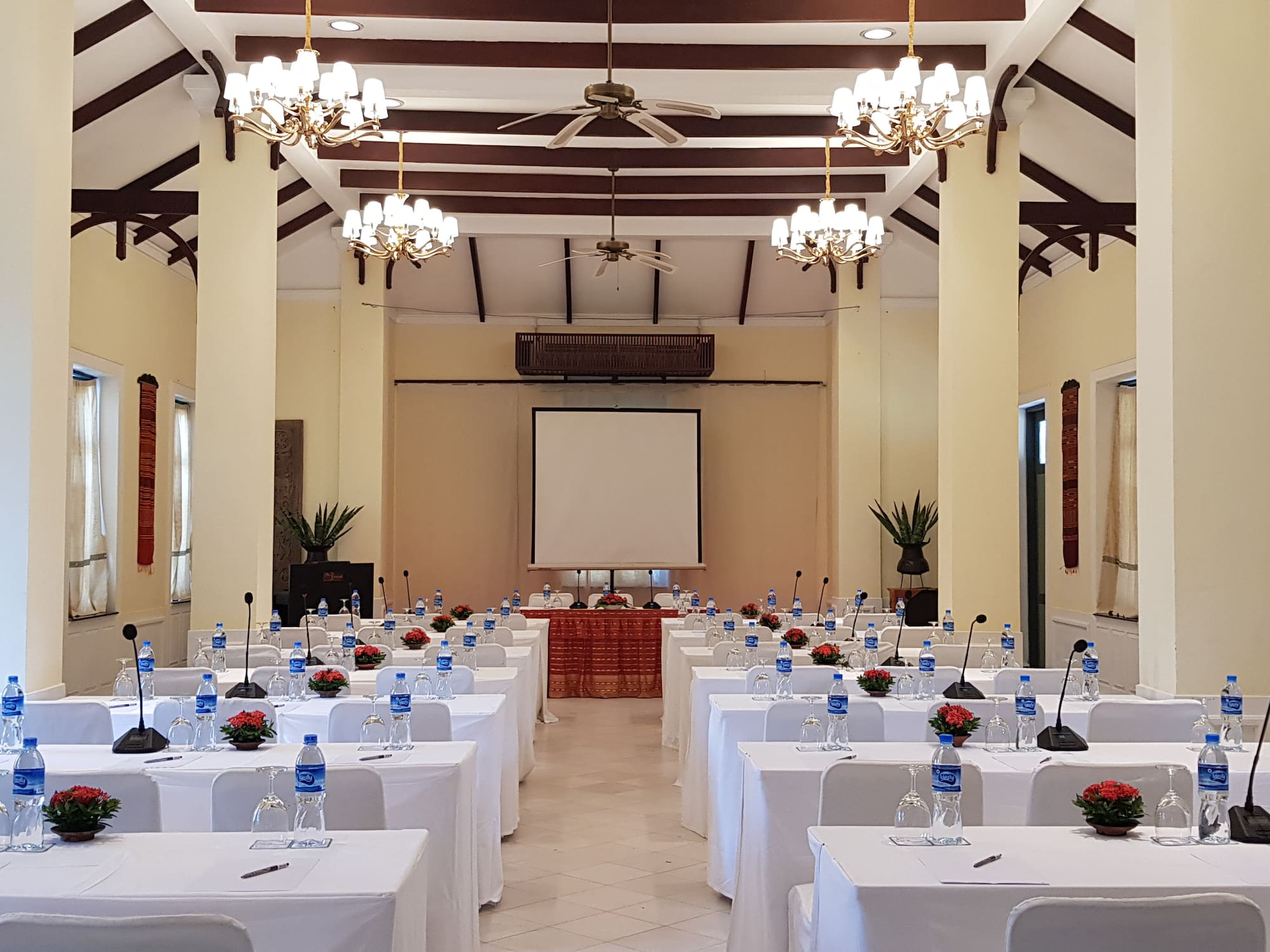 a room with tables and chairs and a projector screen