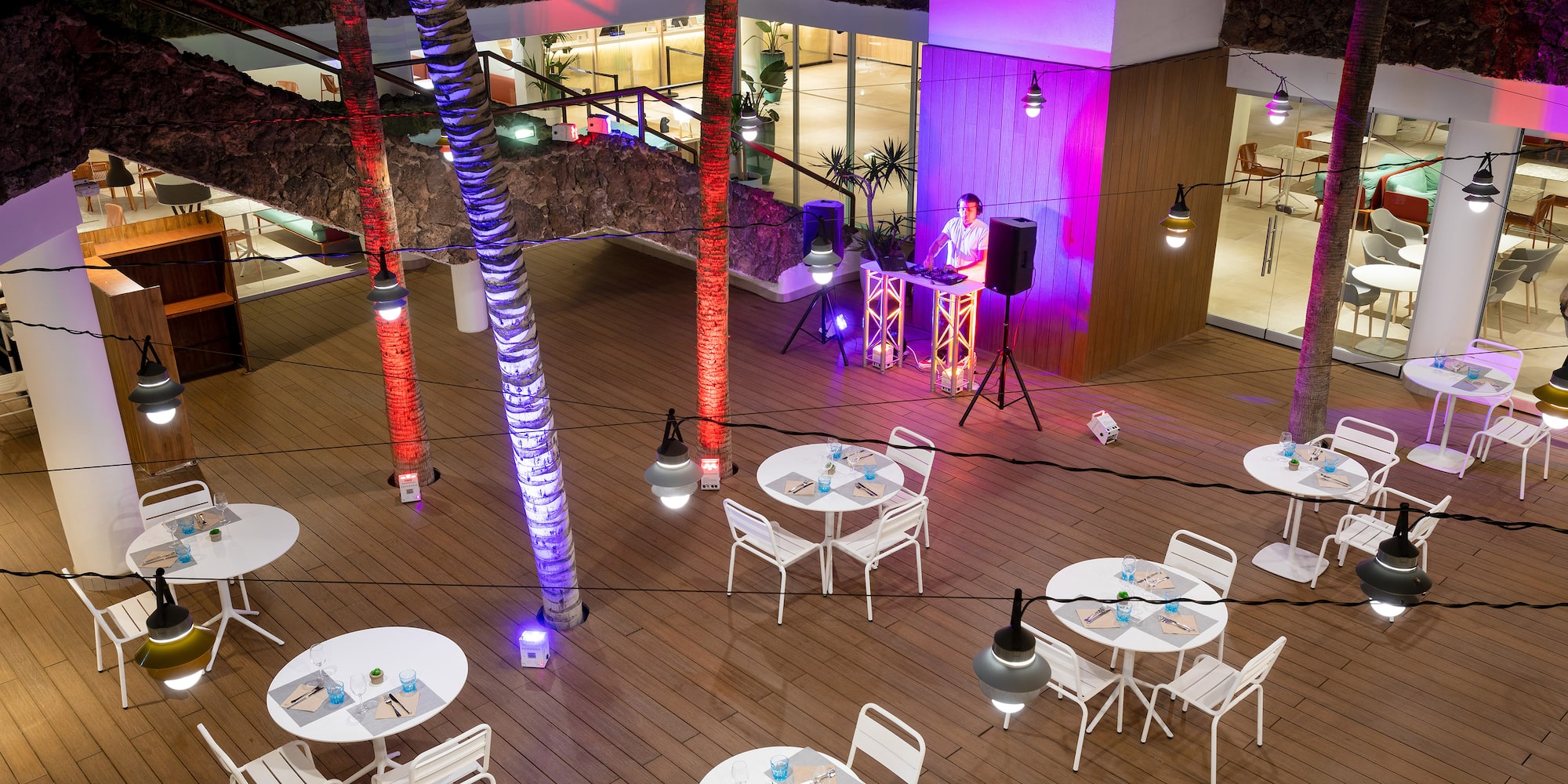 a man standing in front of a stage with tables and chairs