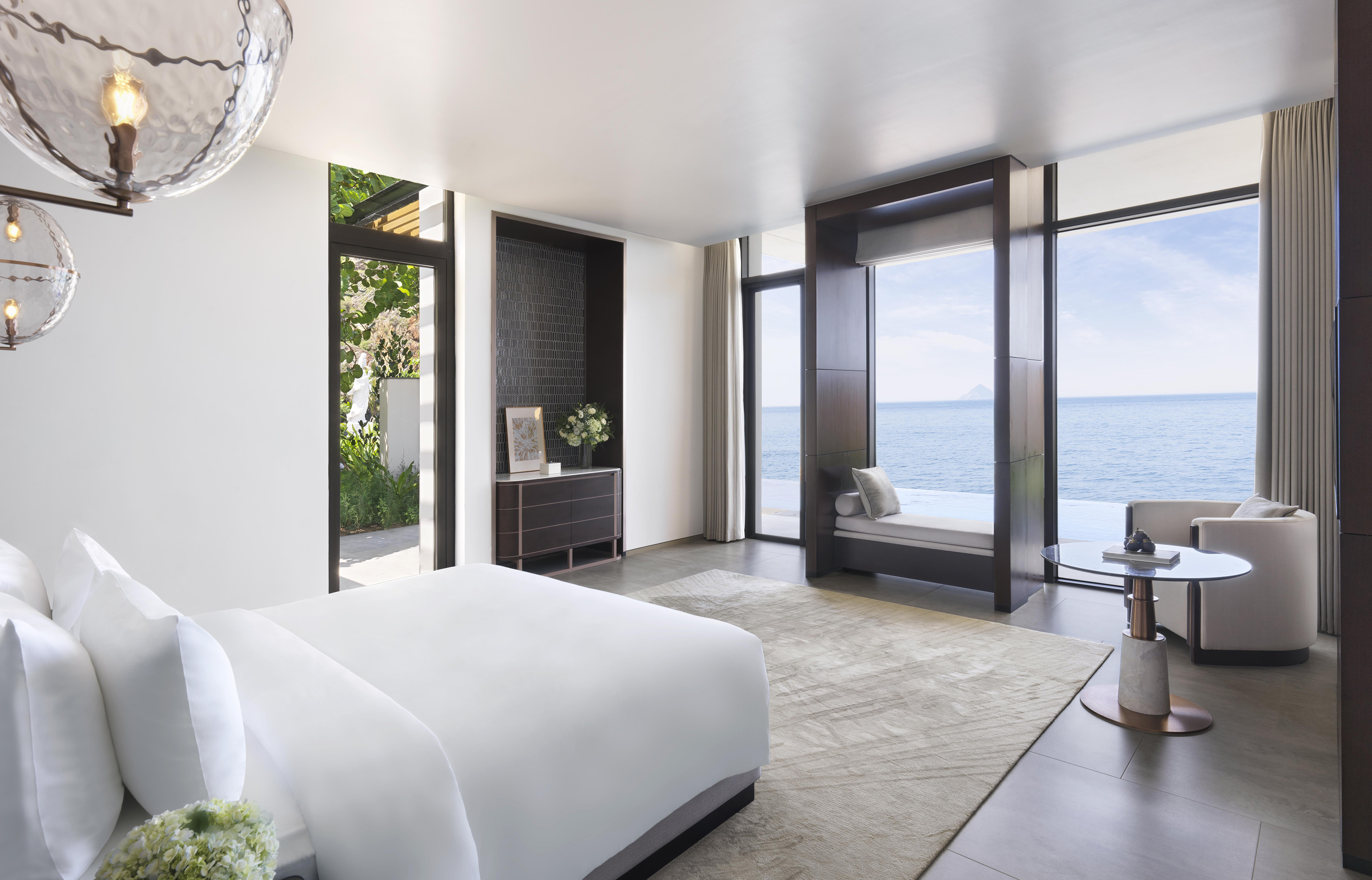 Luxury resort bedroom with panoramic ocean views and modern decor.