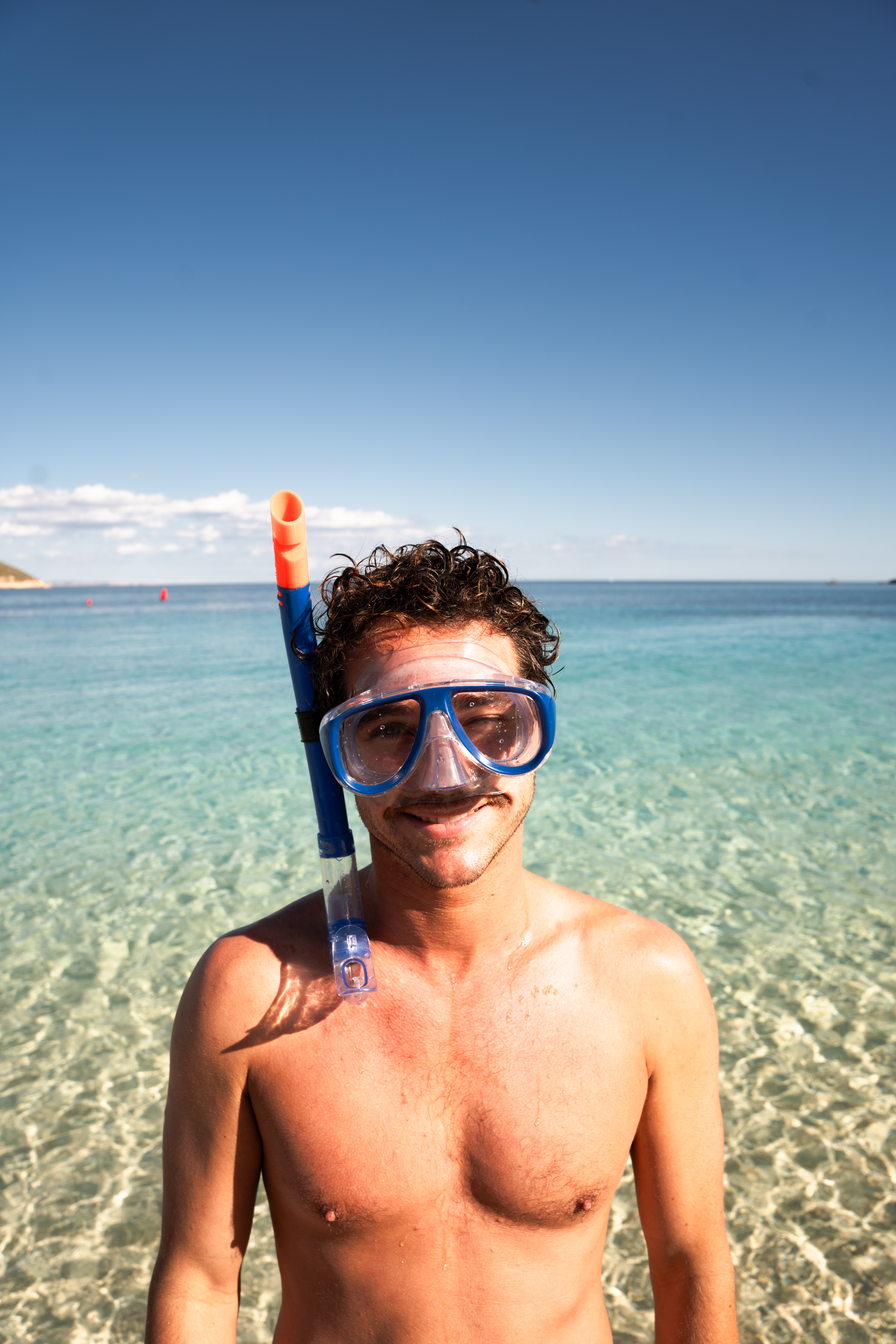 Hombre con máscara de snorkel en aguas turquesas.