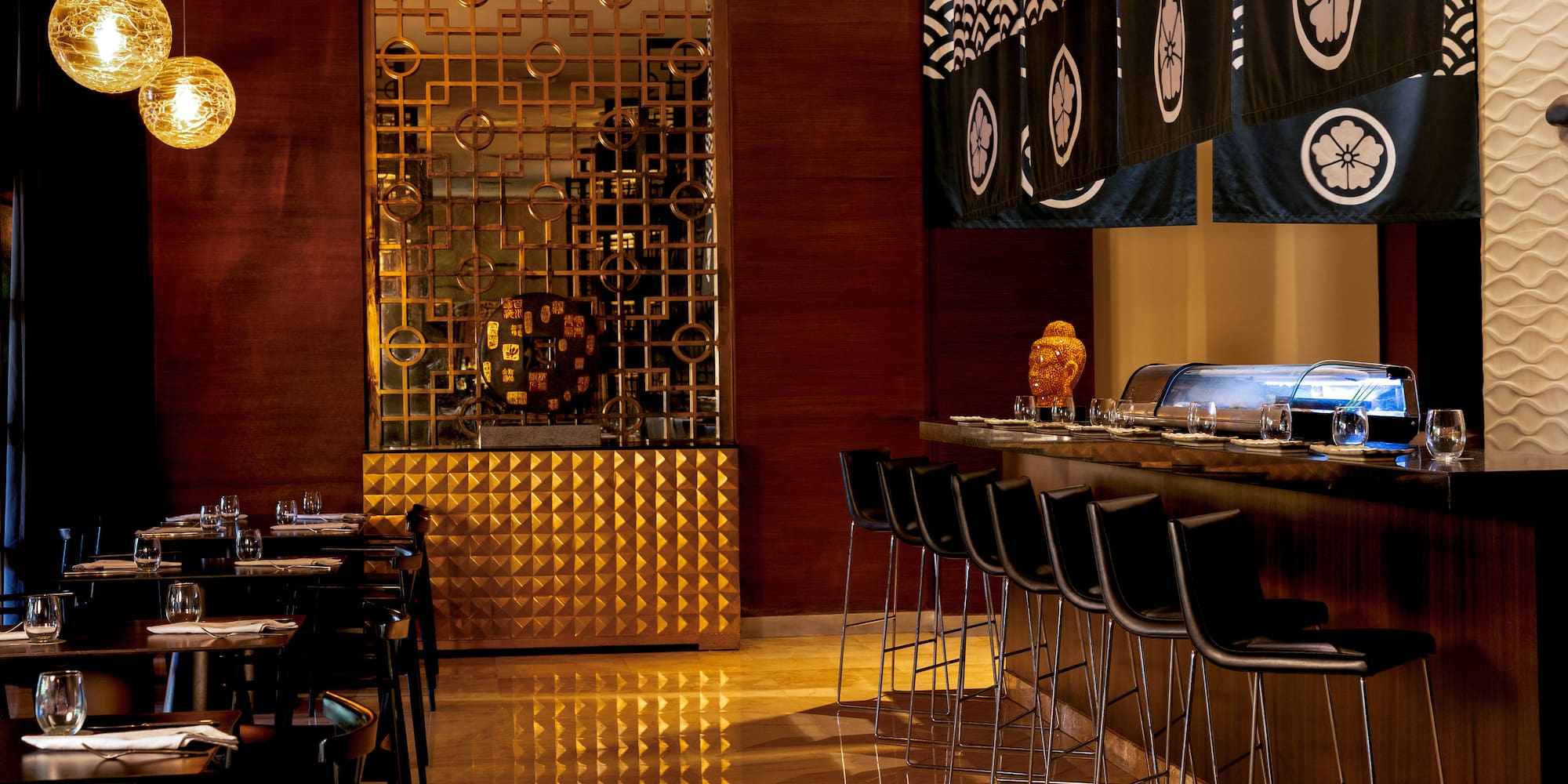 Elegant Japanese restaurant interior with sushi bar, noren, and golden screen.