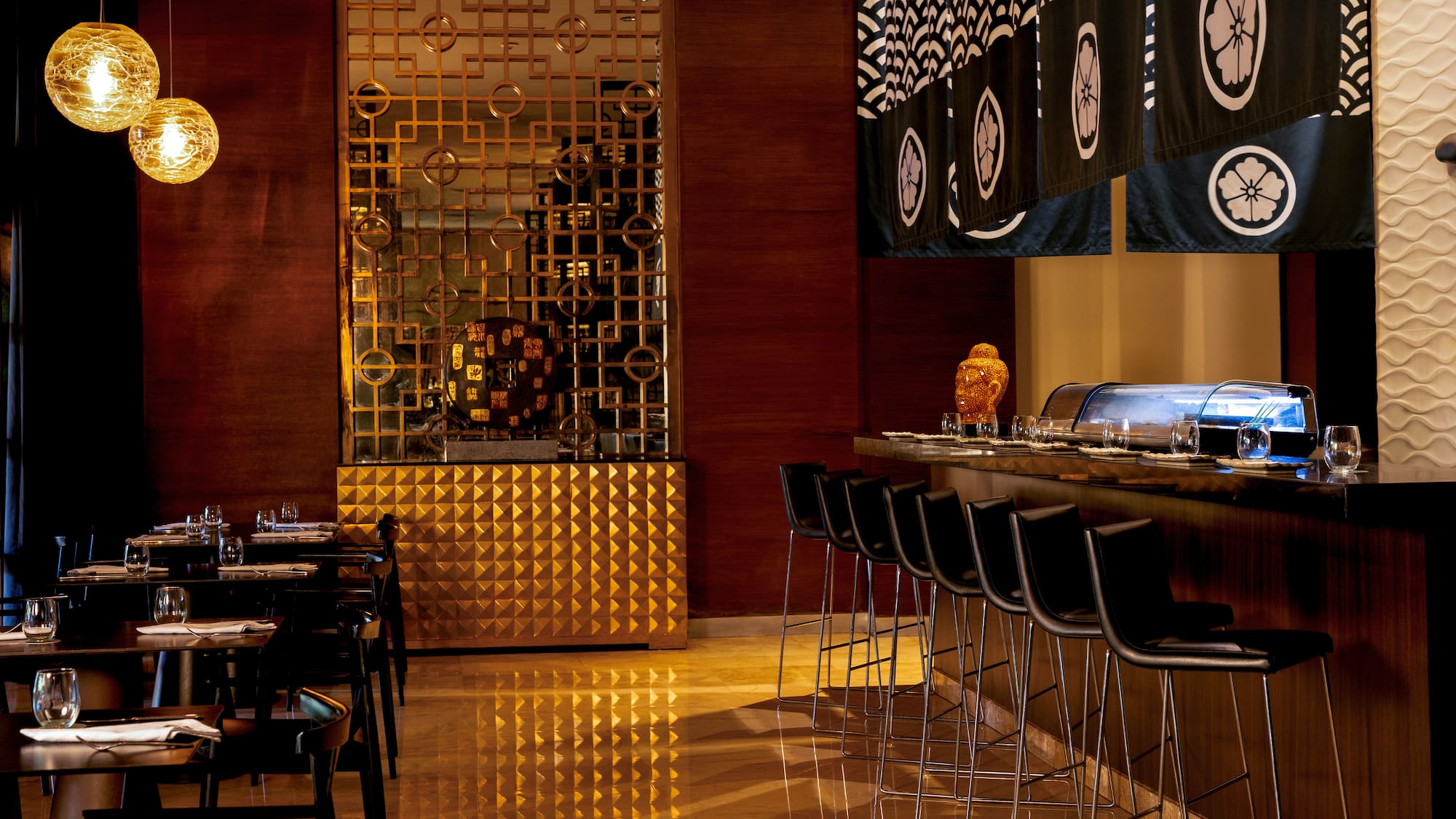 Elegant Japanese restaurant interior with sushi bar, noren, and golden screen.
