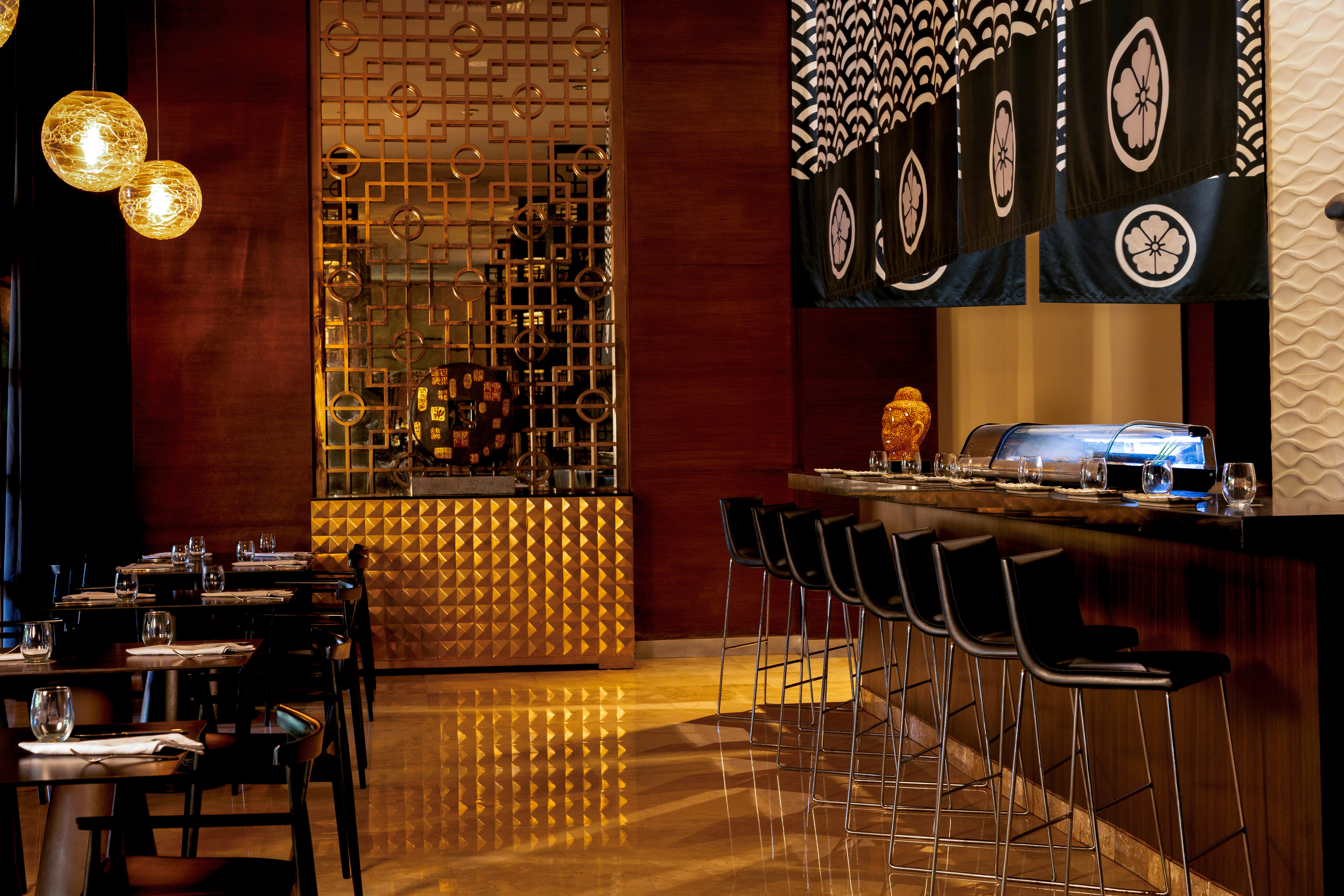 Elegant Japanese restaurant interior with sushi bar, noren, and golden screen.