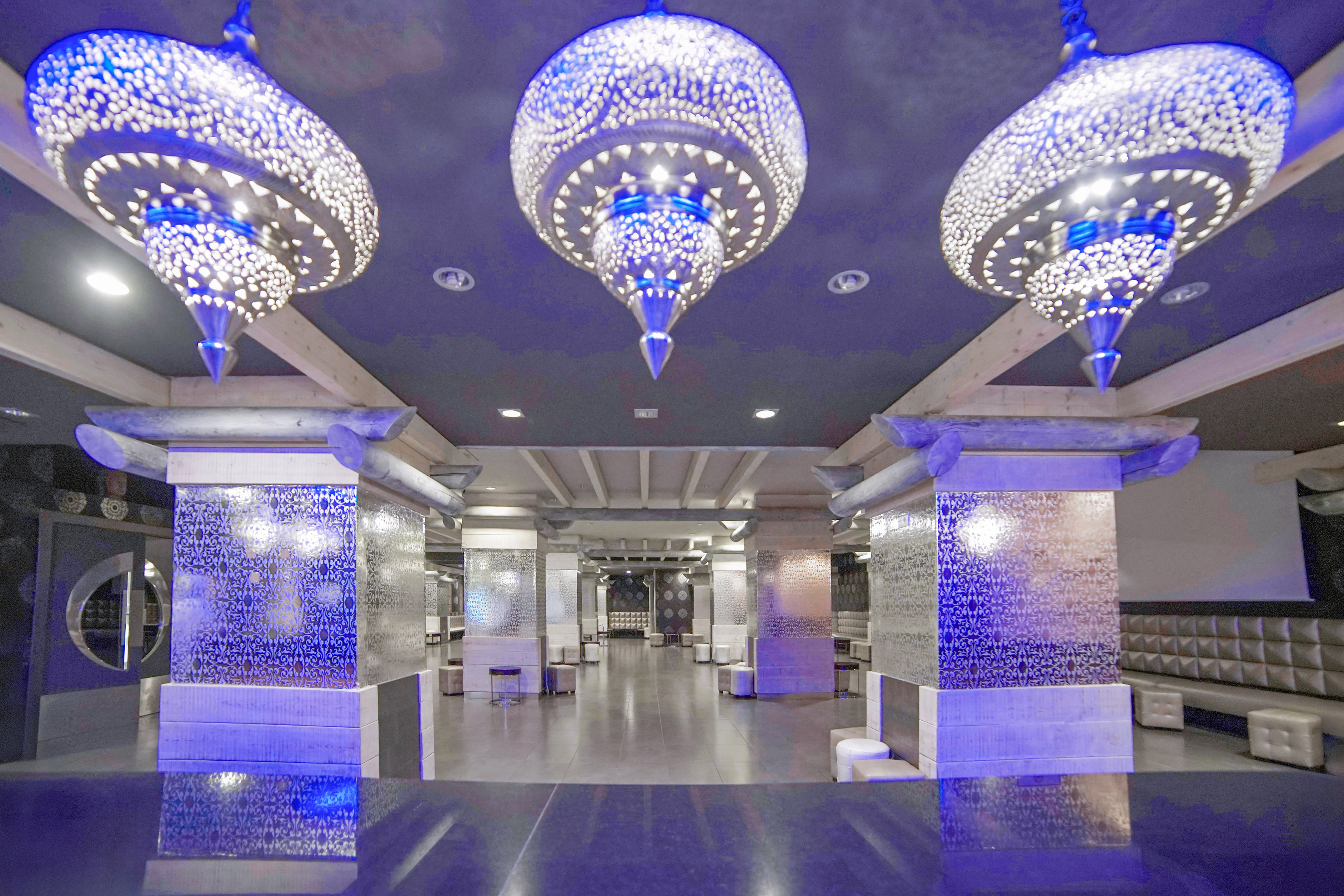 a room with a large chandelier and a tiled floor
