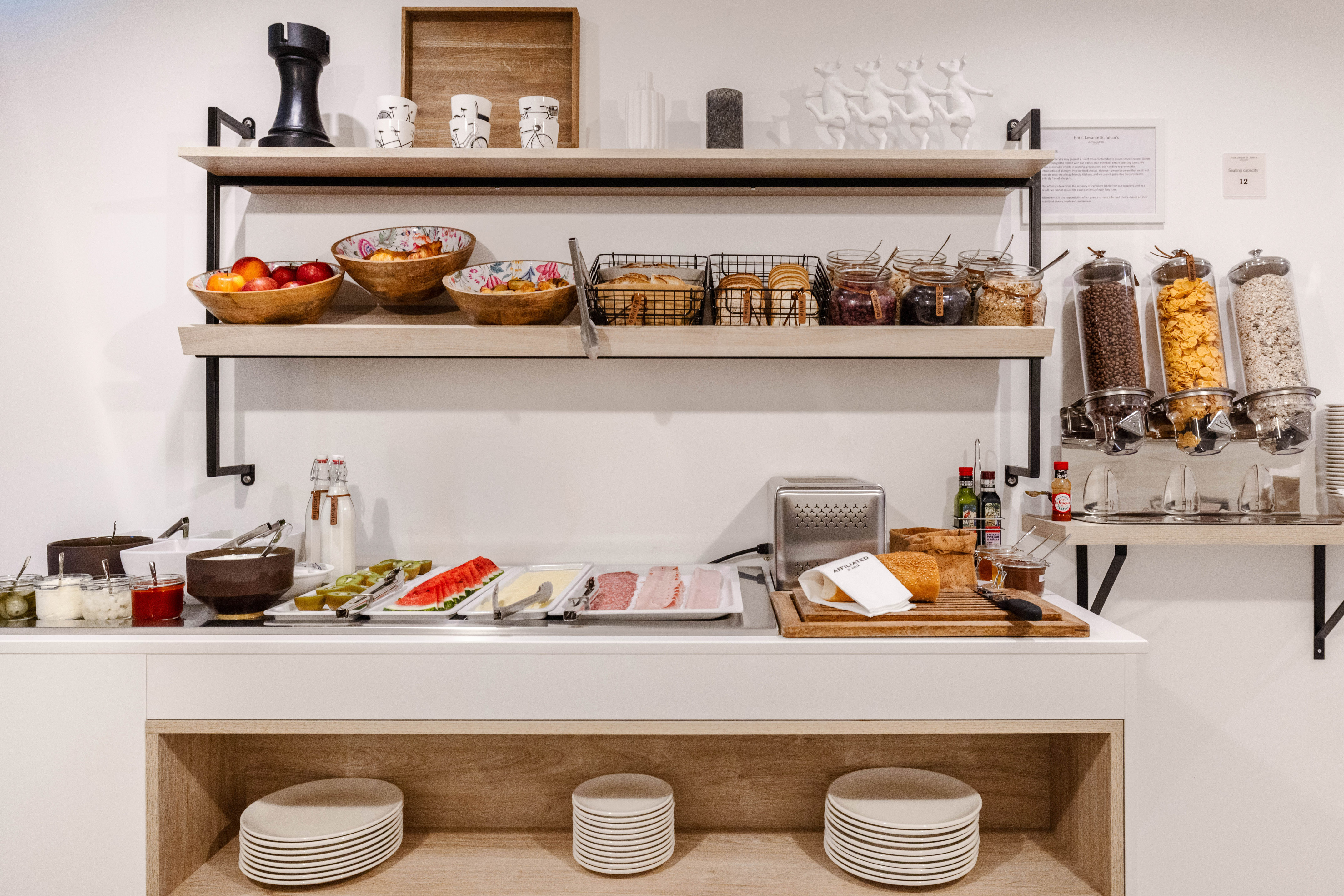 Extensive hotel breakfast buffet: fresh fruit, cereals, pastries, jams, and deli.