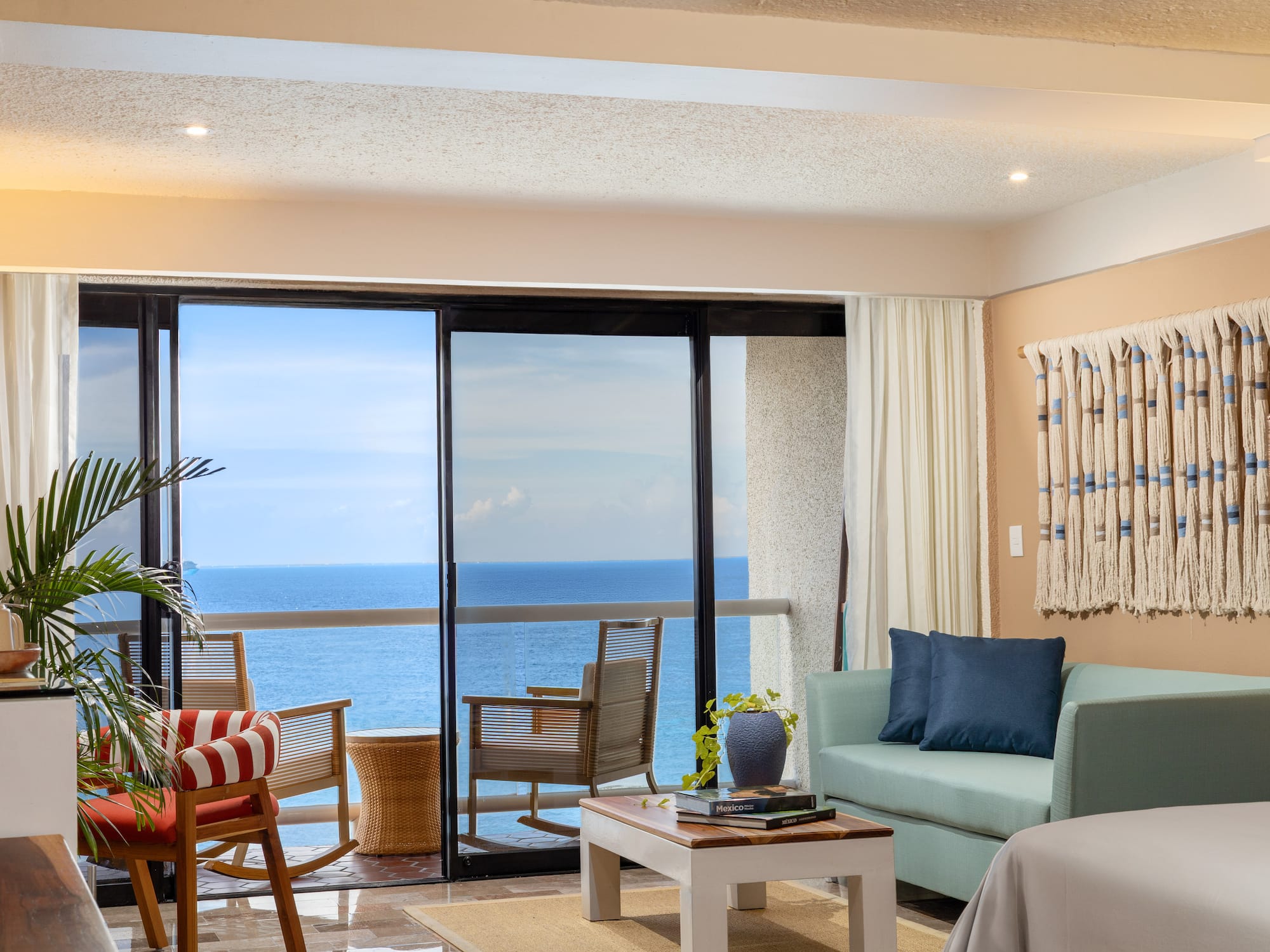 Sala de estar moderna con balcón frente al mar y vista al océano.