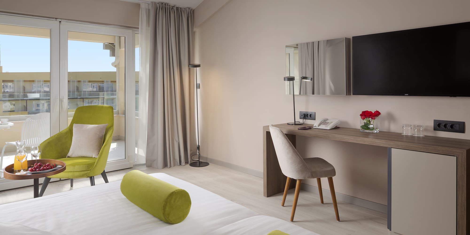 a room with a bed and a desk and a television