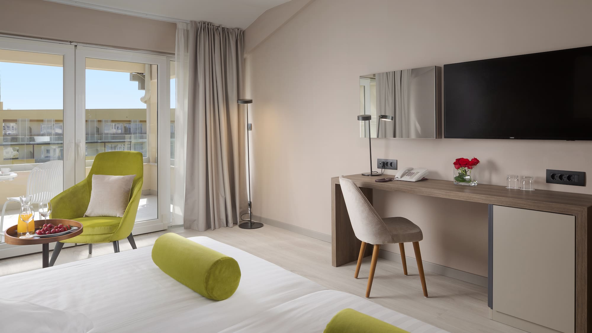 a room with a bed and a desk and a television