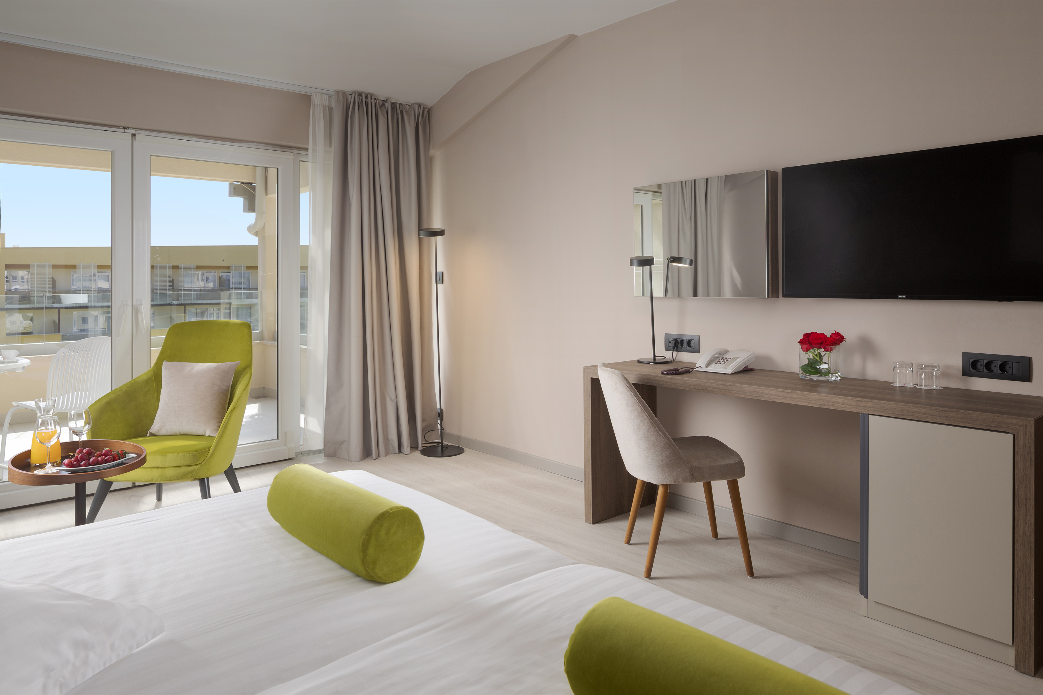 a room with a bed and a desk and a television