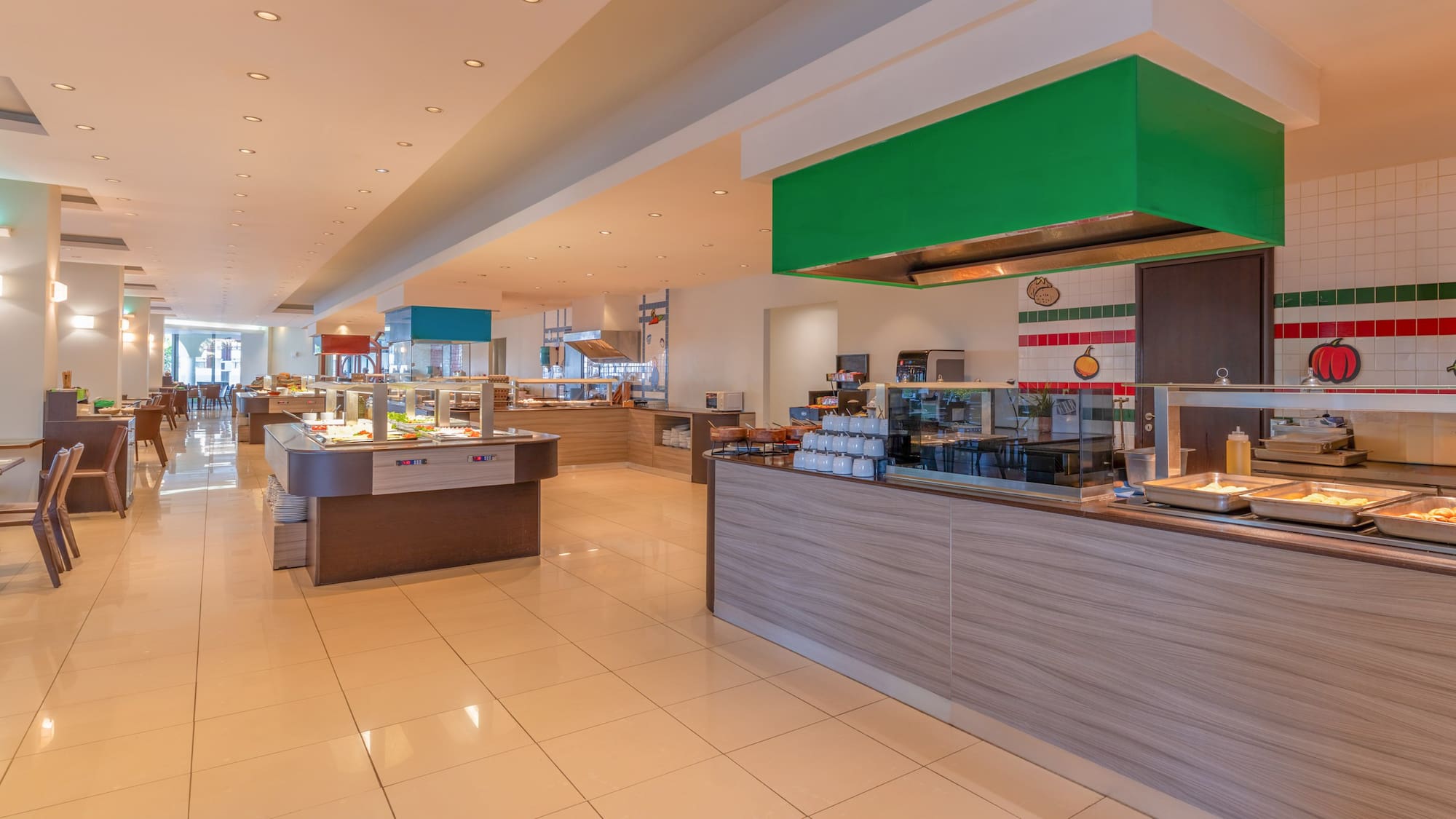 Spacious hotel buffet restaurant with various food serving stations.