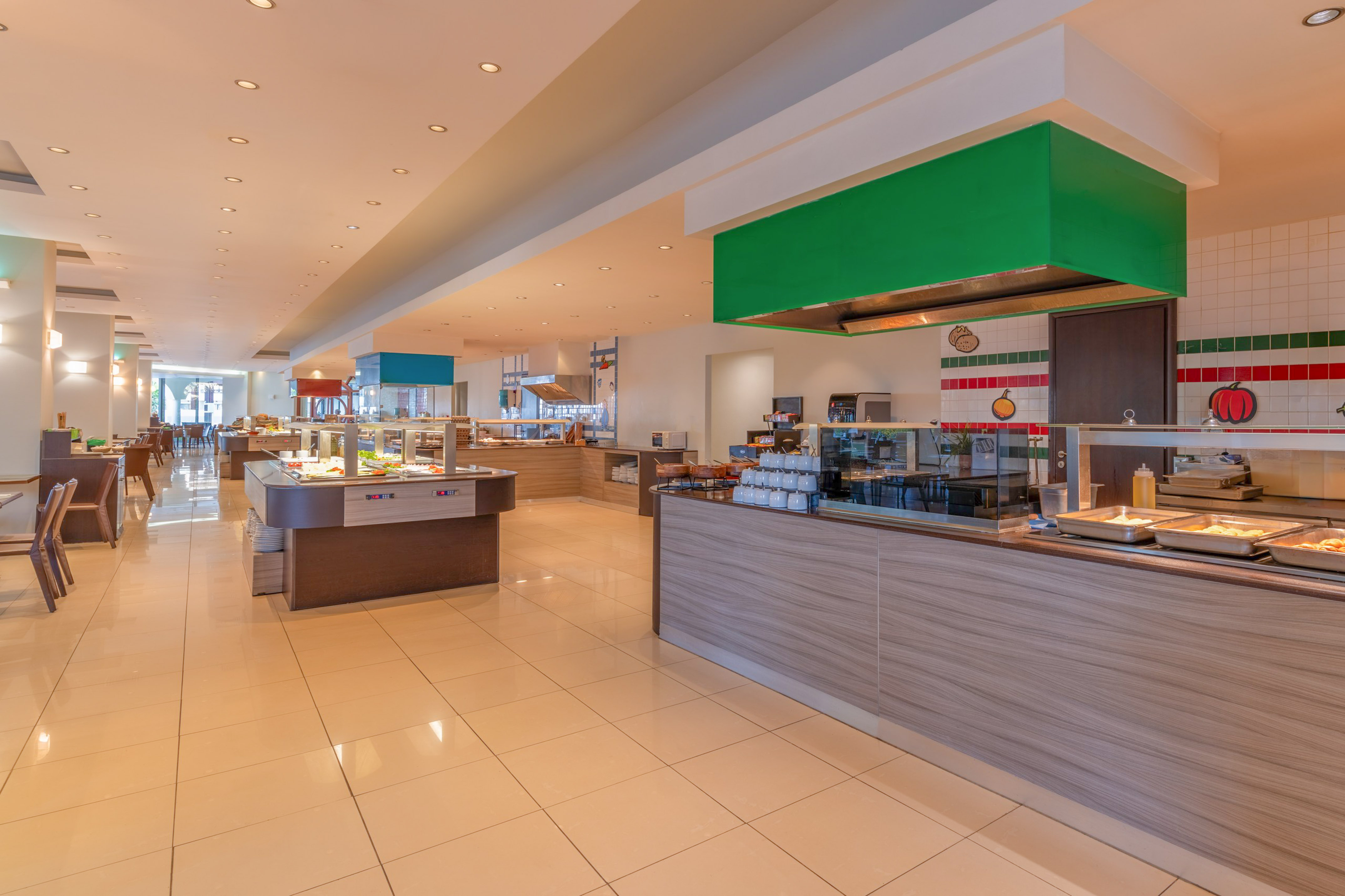 Spacious hotel buffet restaurant with various food serving stations.