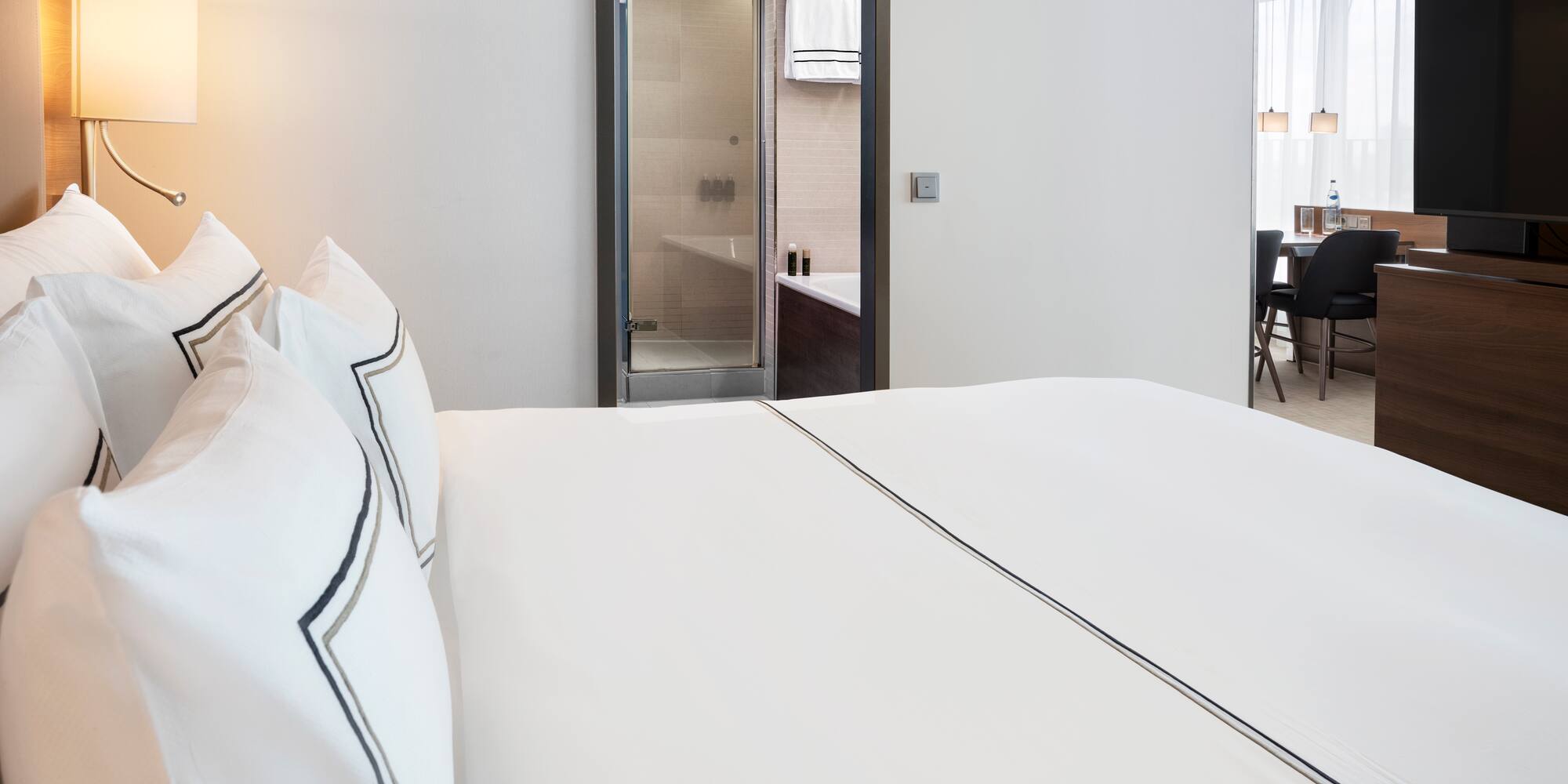 a bed with white sheets and a lamp